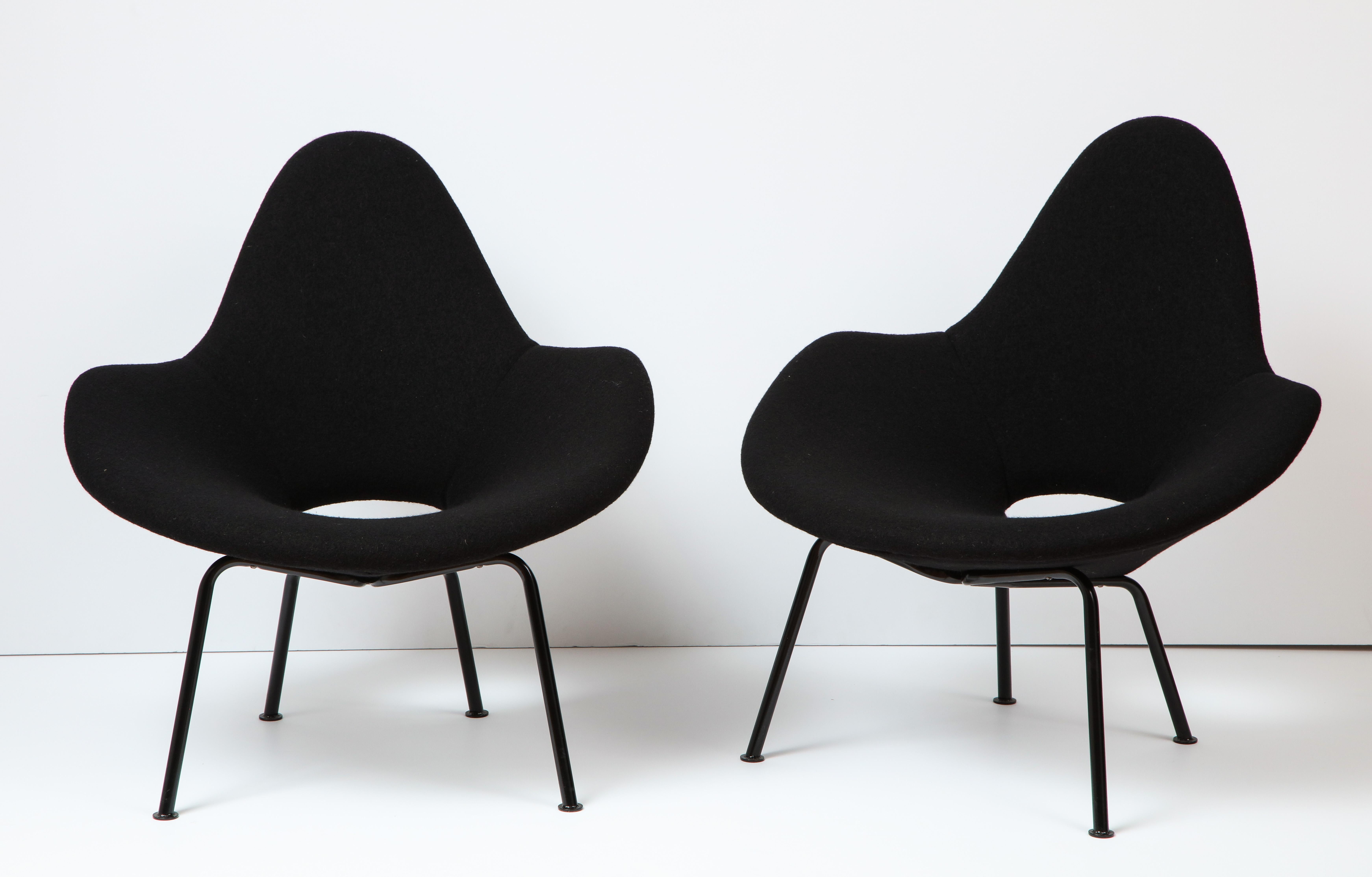 A pair of armchairs upholstered in boiled wool on enameled iron bases.