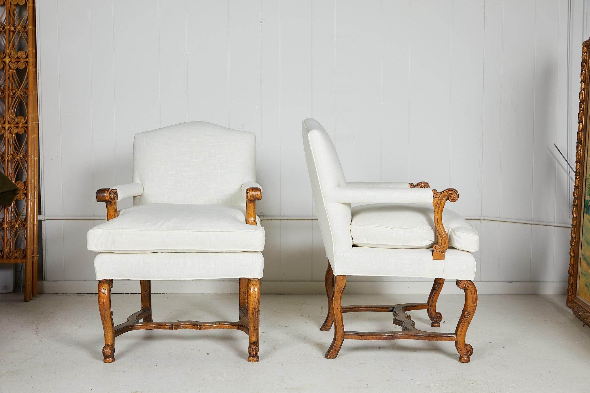 Pair of 20th century Italian open-arm bergère chairs having upholstered backs and seats and custom loose down removable cushions. The fruitwood finish wooden frames have scrolling arms and legs and shaped H-stretchers. The chairs have been newly