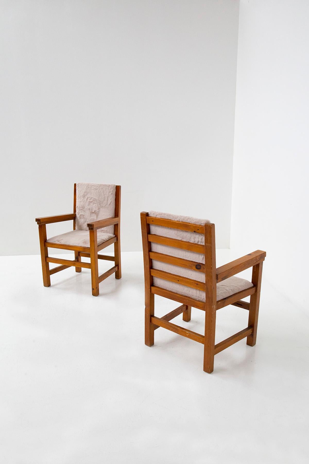 Beautiful pair of Italian armchairs from the 1960s. Collected from a large Italian mountain chalet. The pair of armchairs has a soft and elegant dark pink fur. The frame is made of very solid walnut wood, with shapes typical of mountain