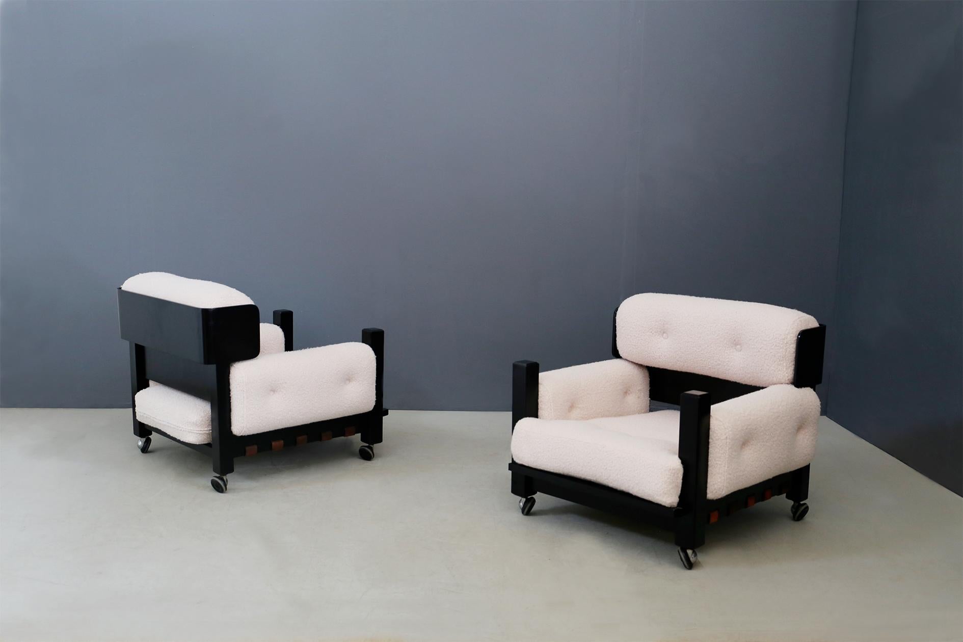 Geometric pair of Italian armchairs from 1960s. The structure of the armchairs is in restored ebonized wood, the seat and backrest cushions are in re-covered white
bouclé fabric.
The peculiarity of the seat is its hand rest made of ebonized wood