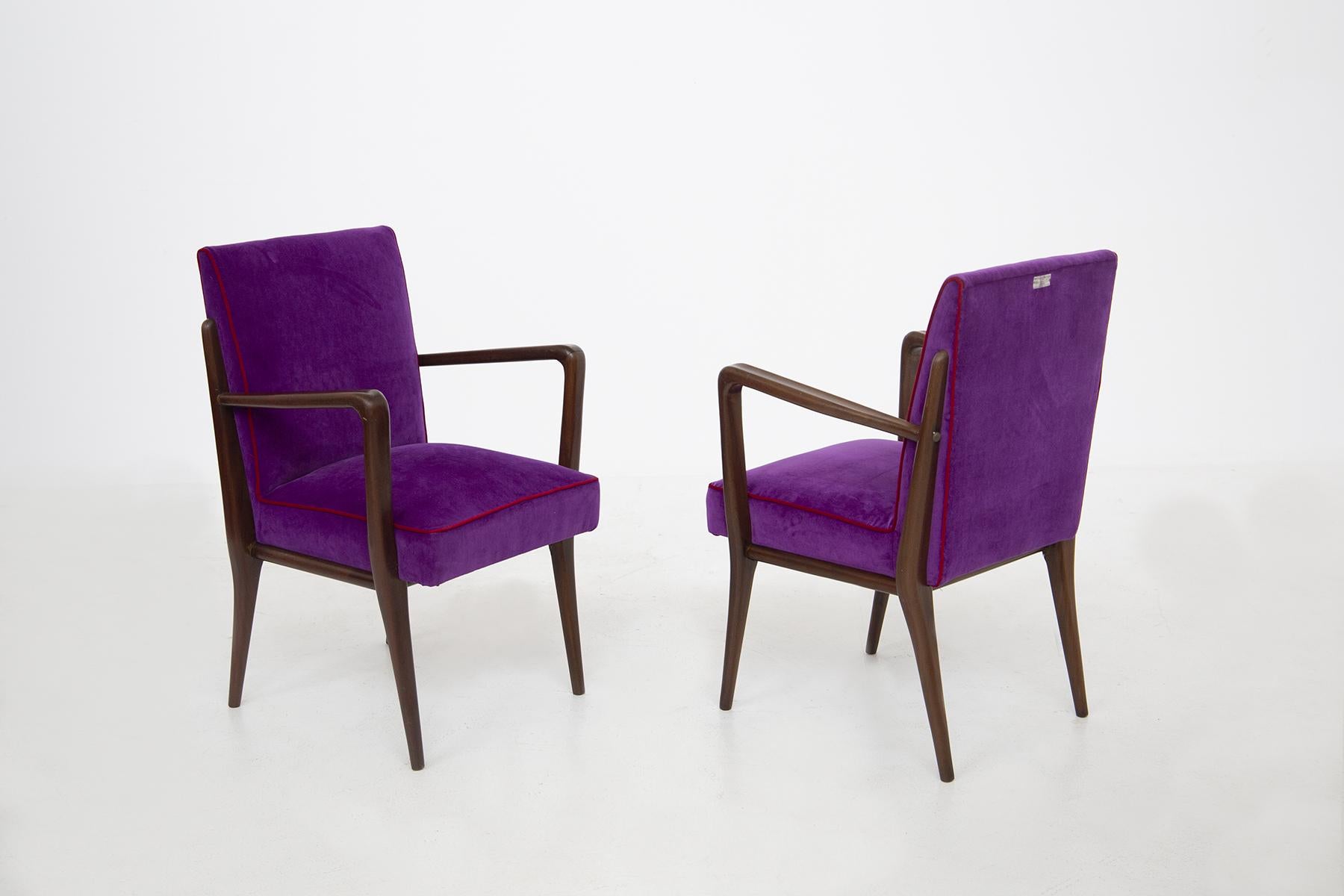 Elegant pair of 1950's Italian armchairs reupholstered in purple velvet fabric. Finishing the velvet seat is an elegant red velvet border that creates an elegant play of color. The frame is made of walnut wood with sharp, geometric lines. Behind the