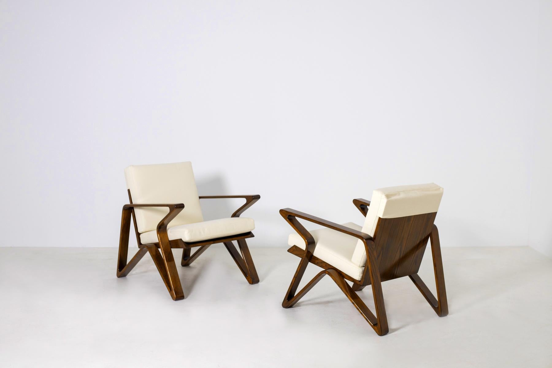 Superb pair of 20th century Italian armchairs. The pair of armchairs were made of fine quality walnut wood. Its futuristic Z shape creates movement and shape to the armchair. Its fine wood reinforces the concept of Italian excellence. Its seat and