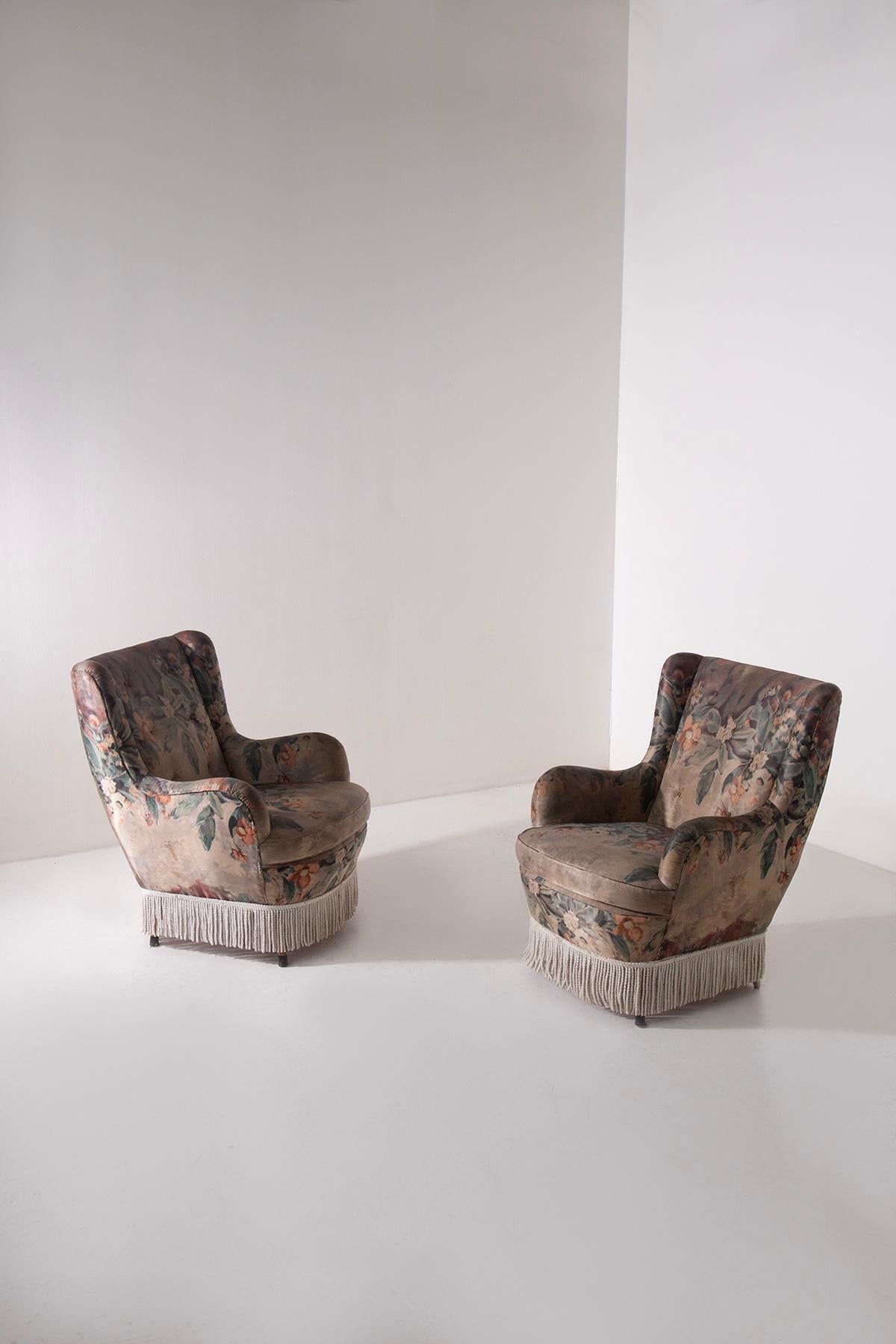 Pair of Italian Armchairs from the 1950s with Original Marelli Fabric – Vintage Design with Decorative Fringes and Cone Legs
This elegant pair of 1950s Italian lounge armchairs is a true example of Italian mid-century modern design. The armchairs