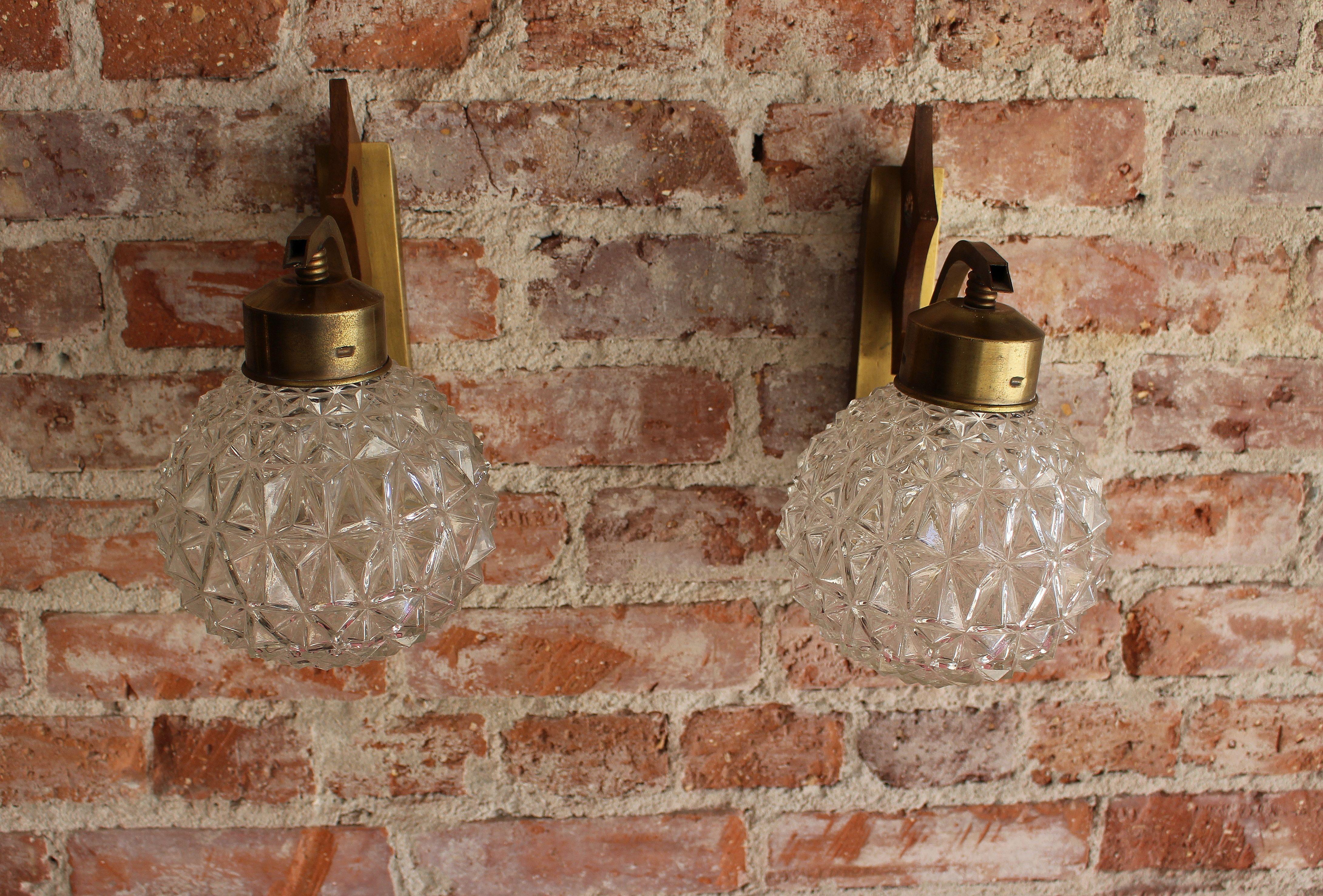 Italian Art Deco pair of wall sconces from the 1940 s period. Brass base and sculptured glass.