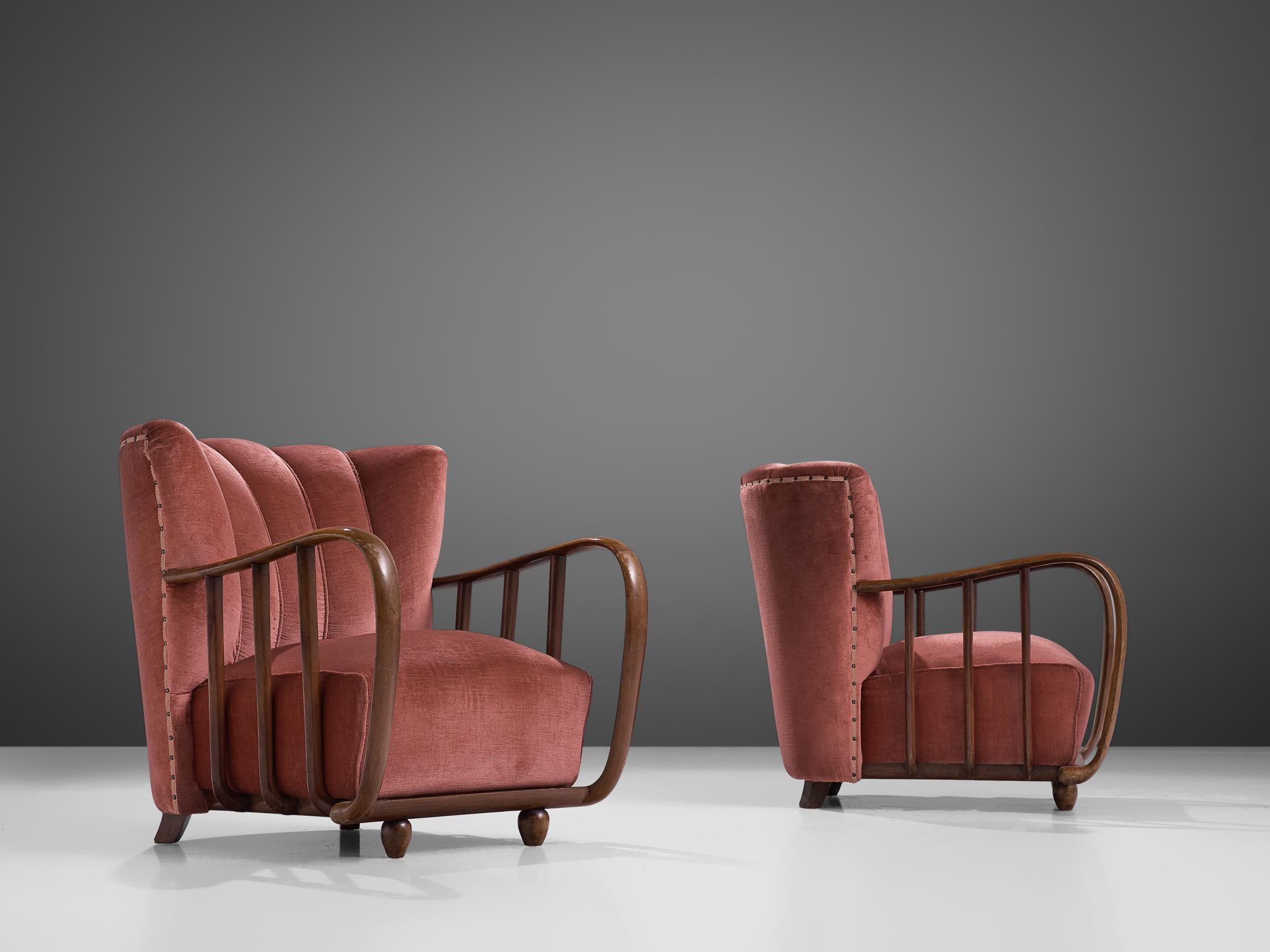 Pair of lounge chairs, beech and fabric, Italy, circa 1940s

Italian pair of armchairs with elegant, rounded shaped frames that feature sculpted details. For instance, the curved wooden detail of the armrests that flows over to the base. Also the