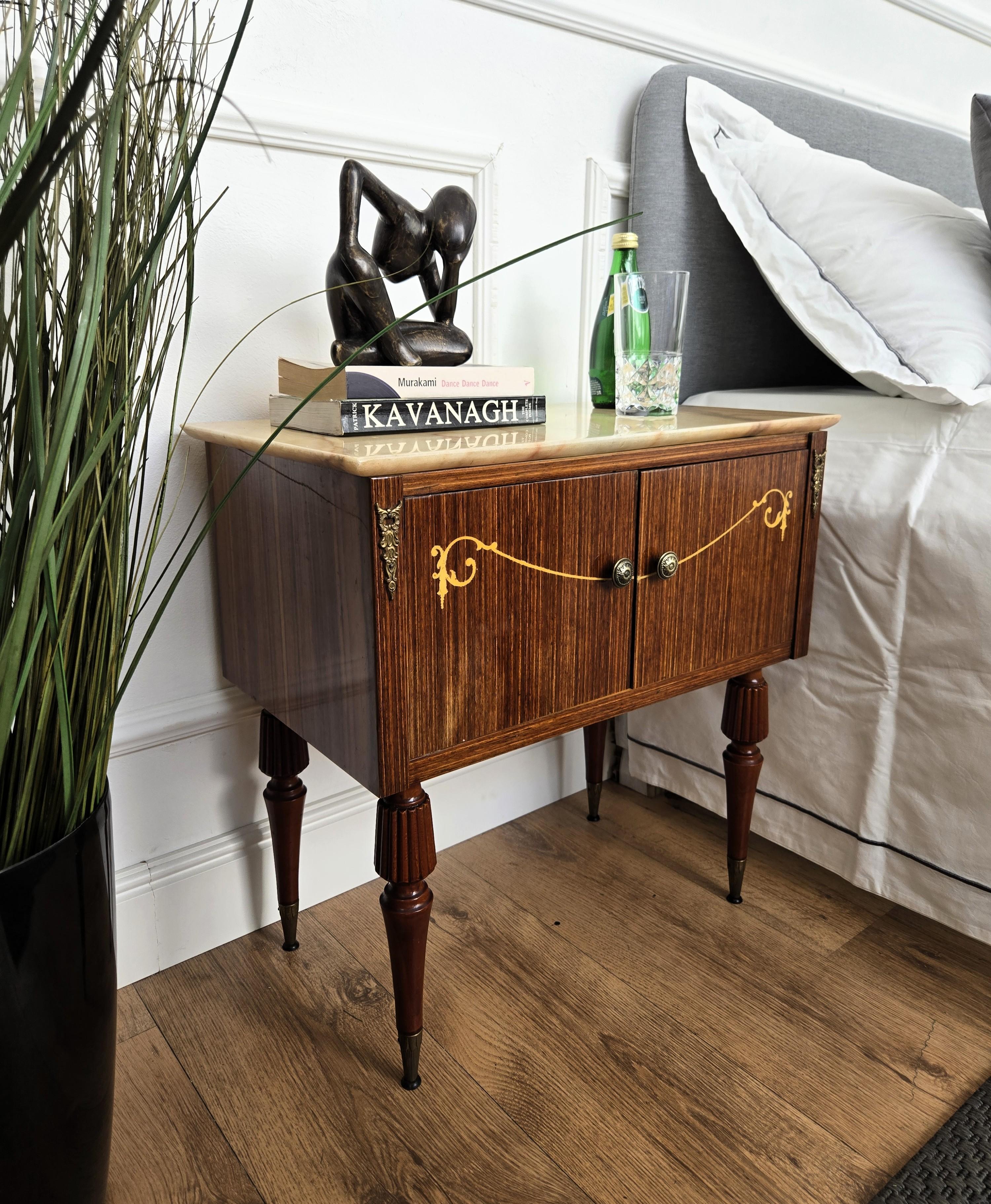 Very elegant and refined Italian 1950s Art Deco Mid-Century Modern pair of night stands bed side tables with great decorated wooden structure and two front doors completed by the white marble top with beautiful brass handles and grooved legs with