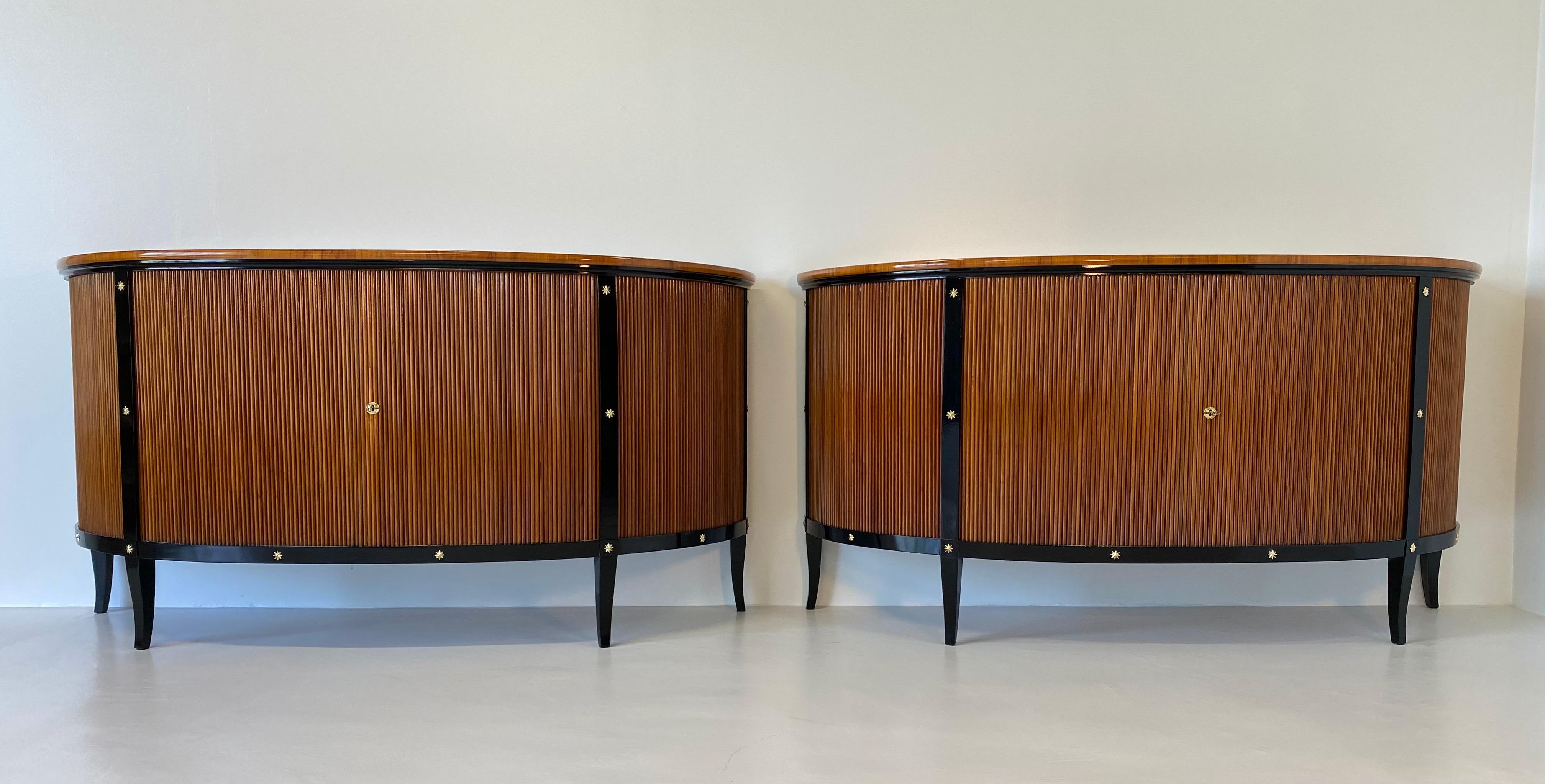 This pair of Art Deco style sideboards were produced in the late 1950s in Italy and are entirely in cherry wood with black lacquer profiles and decorations.
The opening of this items is with sliding doors that hide inside the sideboard once you