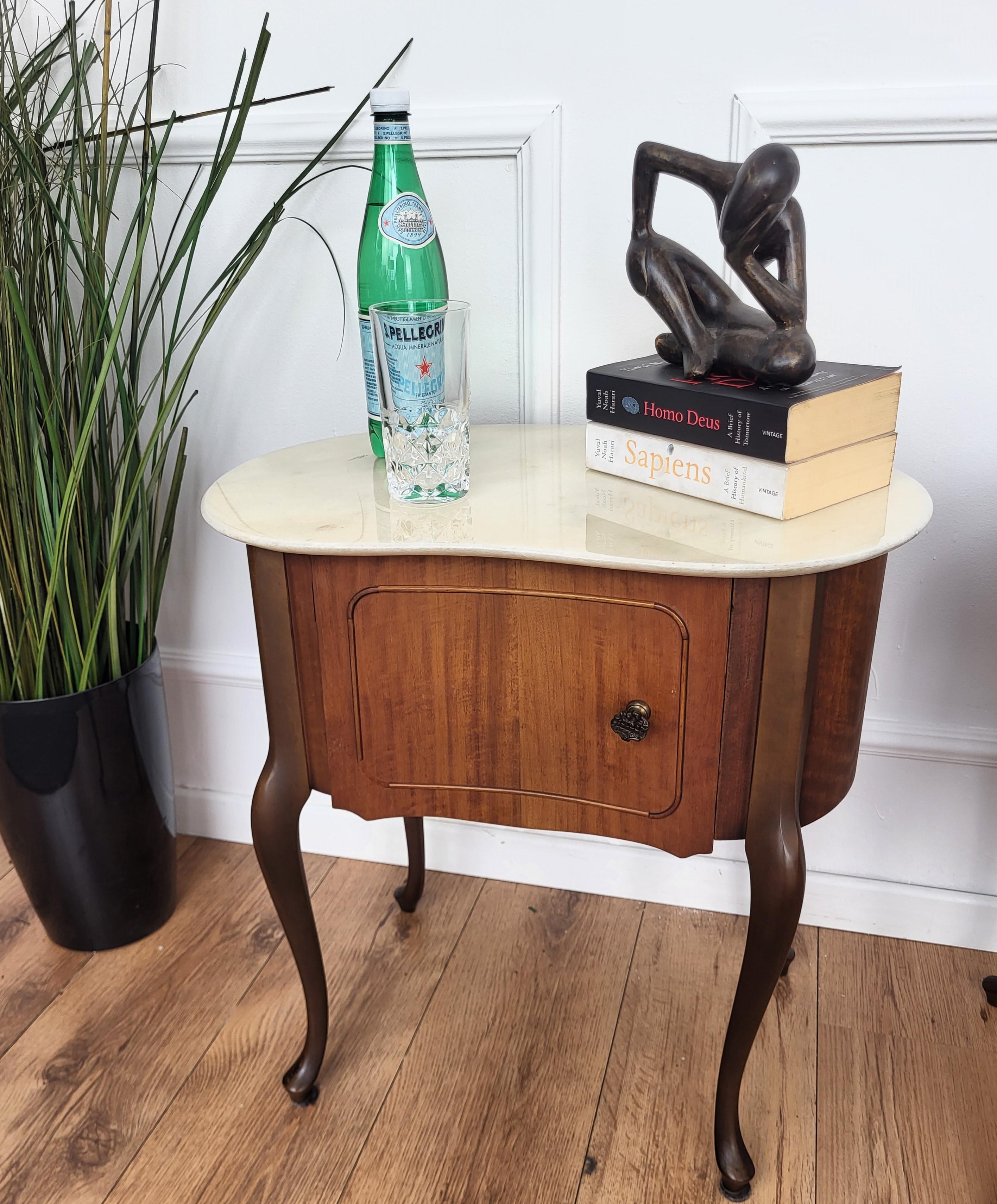 Very elegant and refined Italian Art Deco design, pair of bedside tables in kidney design shape with wood front door, white marble top standing on four saber legs. 

Those pieces make a great look in any style bedroom, as a complementary design or