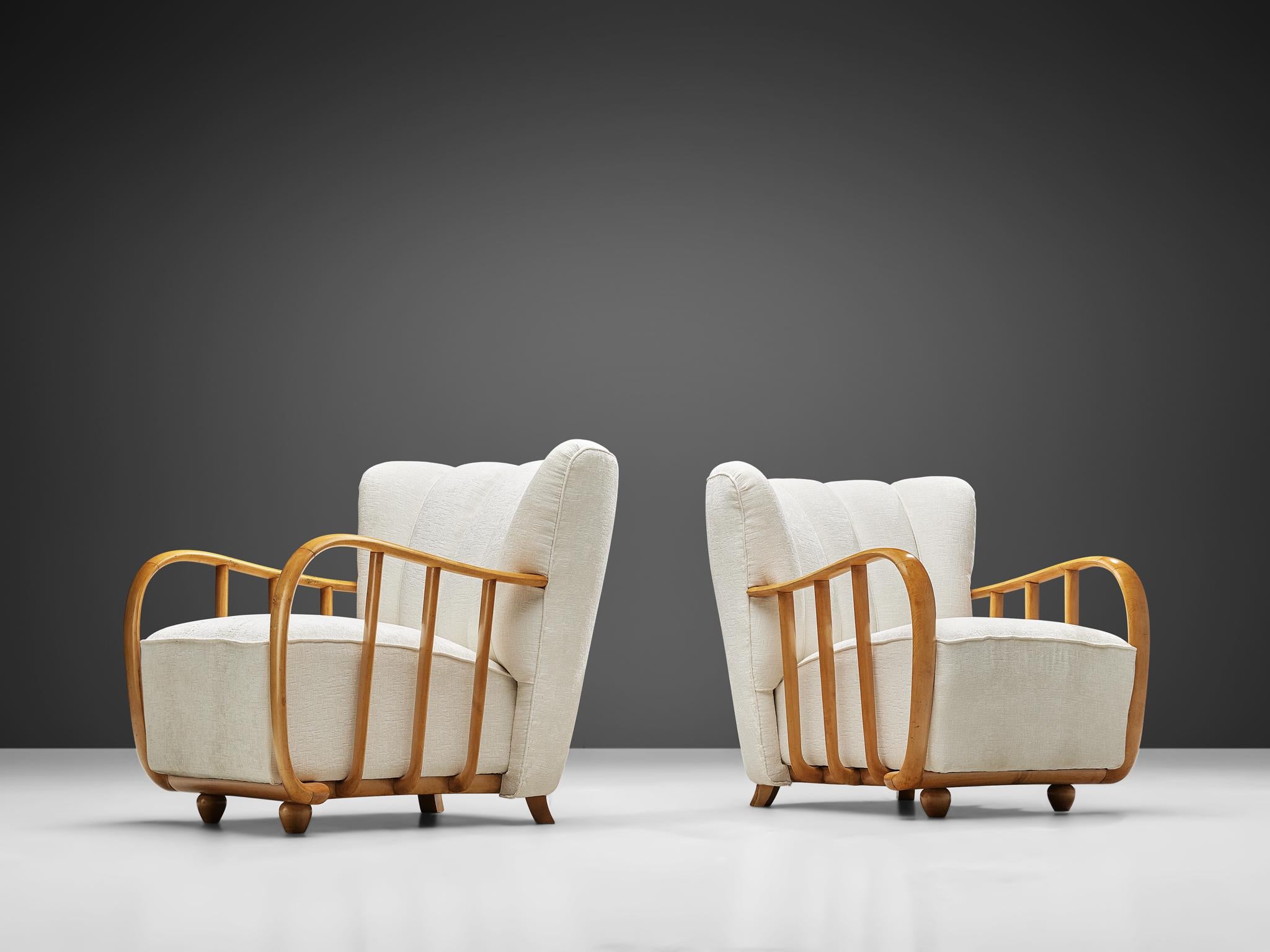 Pair of easy chairs, beech, white textured upholstery, Italy, 1940s.
 
Set of Italian armchairs in late Art Deco style of the 1940s. The most distinctive feature of these easy chairs are the beech armrests elegantly curved around the seating. The