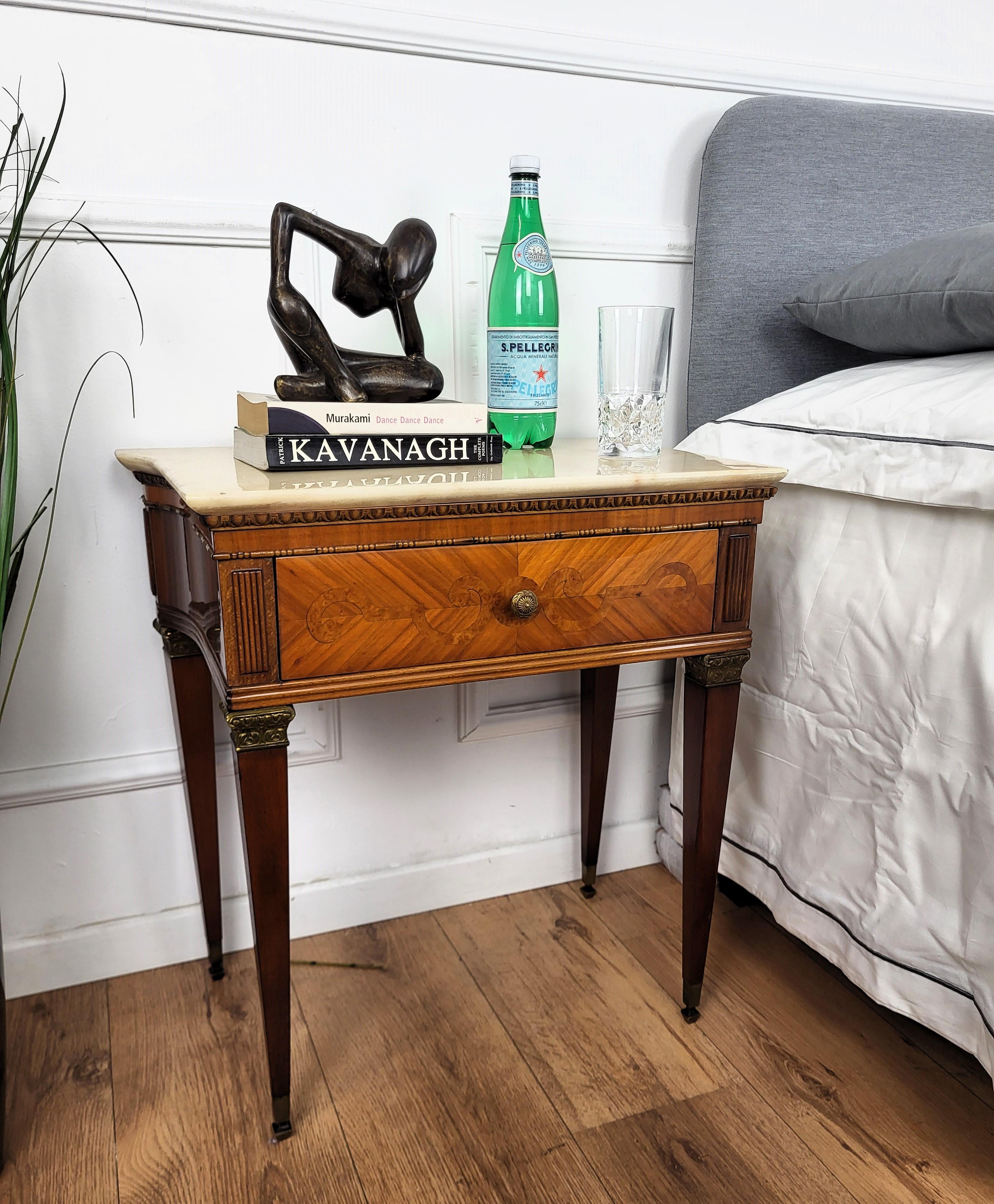 Very elegant and refined Italian 1950s Art Deco Mid-Century Modern pair of night stands bed side tables with greatly carved marquetry detail decorated wooden structure, one front drawer and nicely shaped white marble top with brass details and