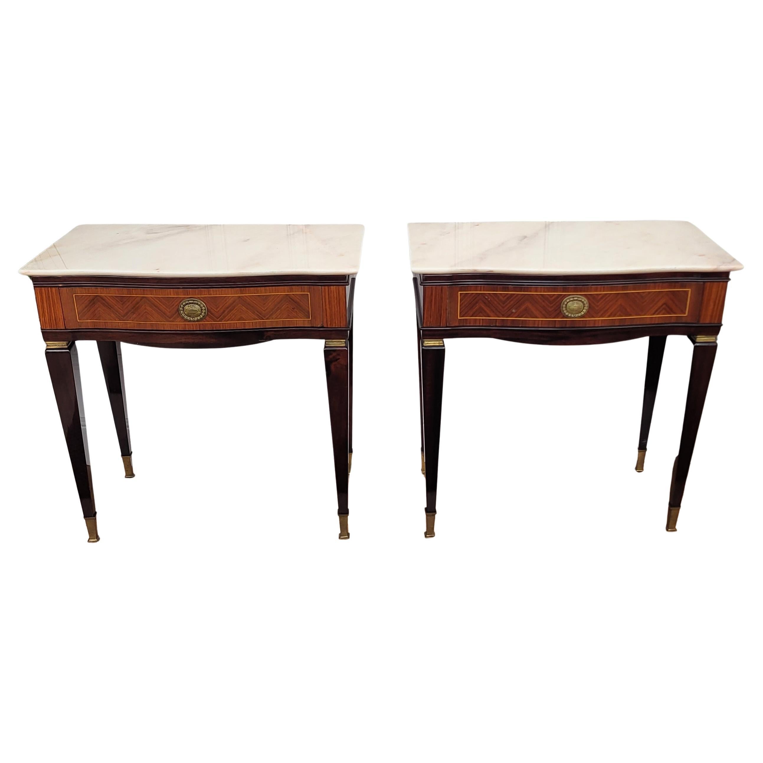 Very elegant and refined Italian 1950s Art Deco Mid-Century Modern pair of night stands bed side tables with greatly carved marquetry detail decorated wooden structure, one front drawer and white marble top with brass details and black squared
