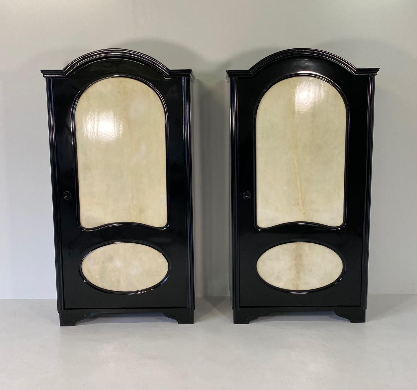 This elegant pair of twin armoires was produced in Italy in the 1930s. 
They are completely black lacquered with particular parchment decoration on the front. Elegant interiors. 
They have been finely and completely restored.