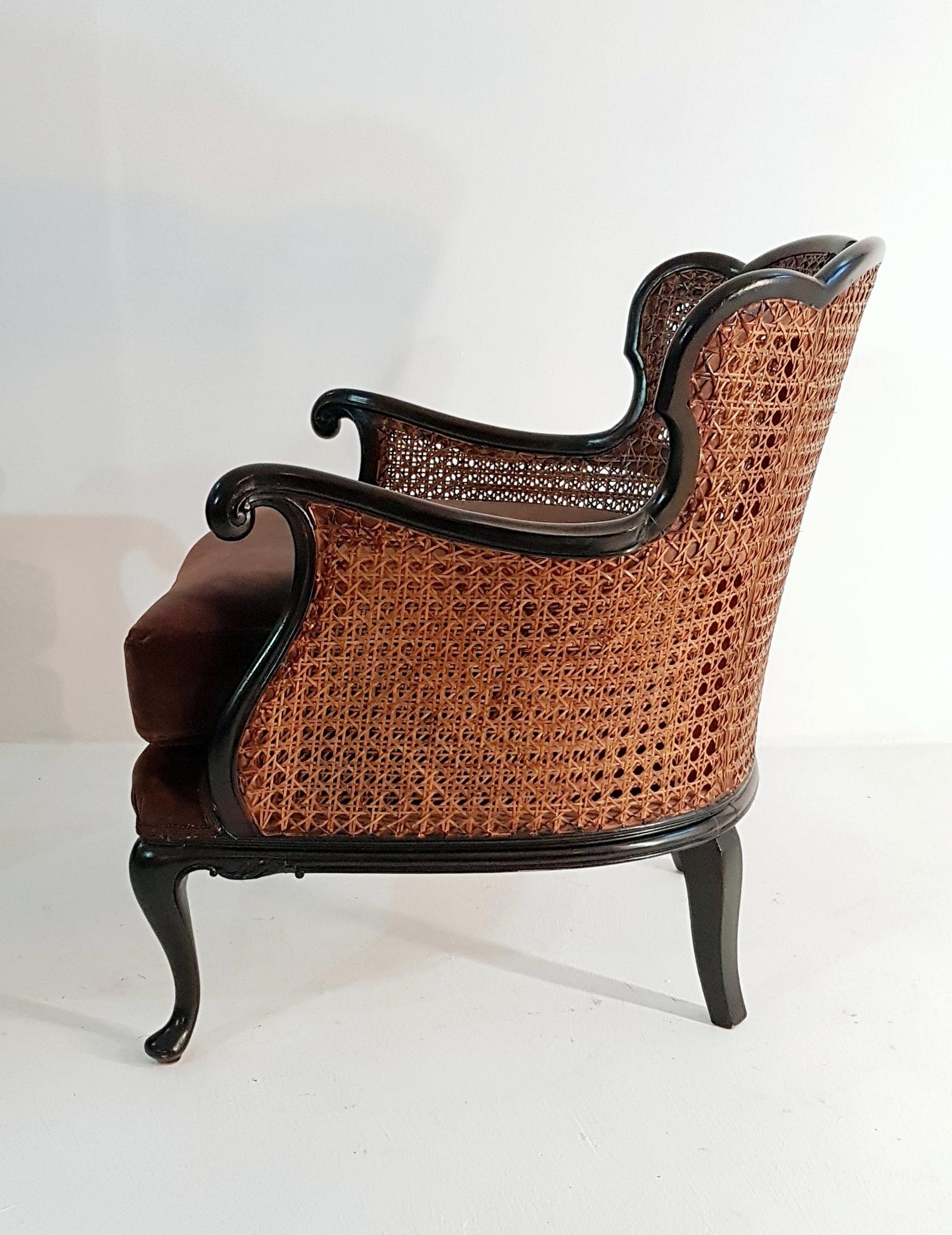 A pair of beautiful Italian Art Deco armchairs in Rococo style. These armchairs has been professionally restored in the structure (wood) as well as upholstery. The frame is made in blackened wood and rattan which is in perfect condition and the