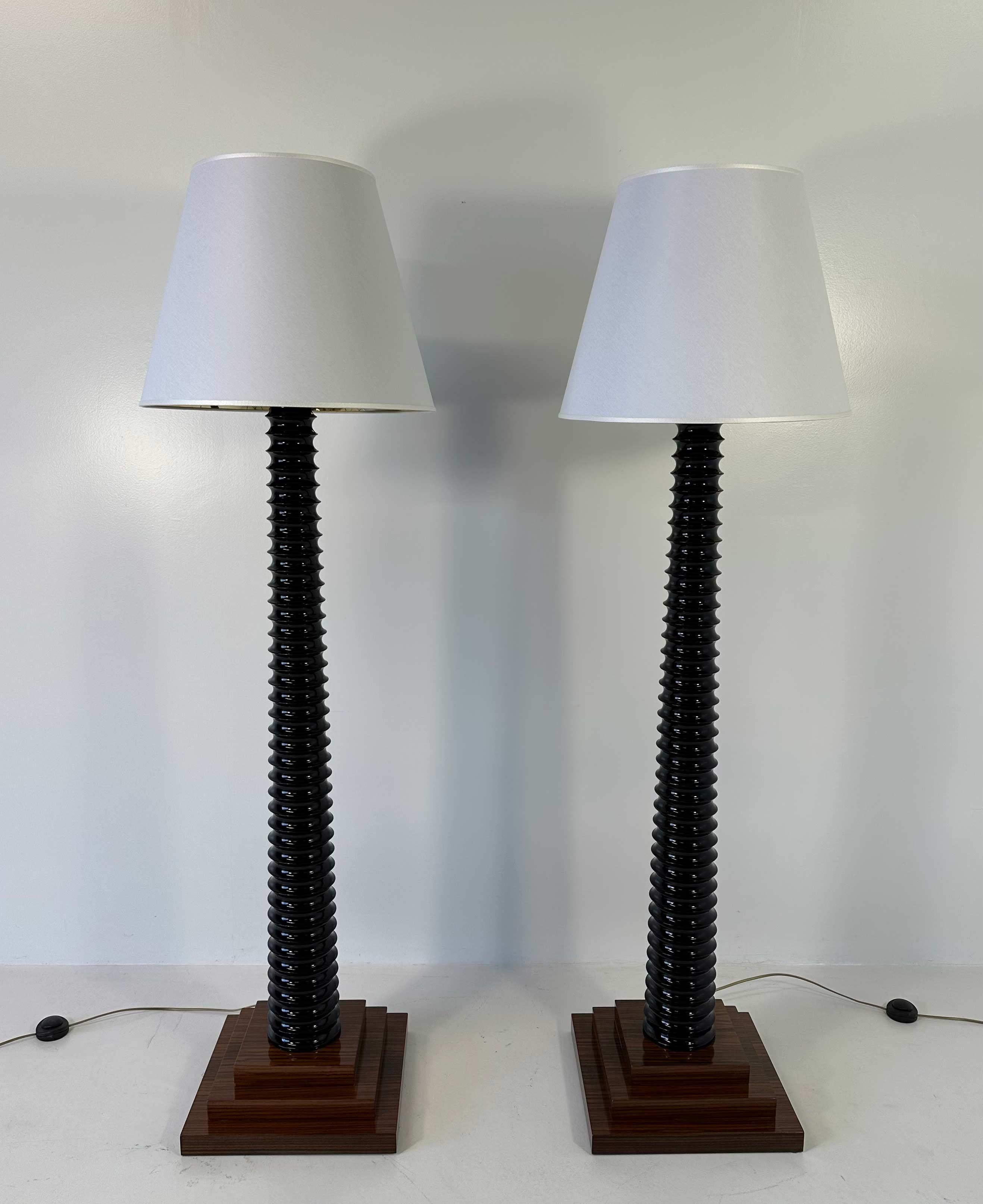 This pair of Art Deco style floor lamps was produced in Italy in the 1980s. 
It is made of turned black lacquered solid wood. 
The fine lampshade is in white velvet and the inside is golden, which creates a warm atmosphere. 

