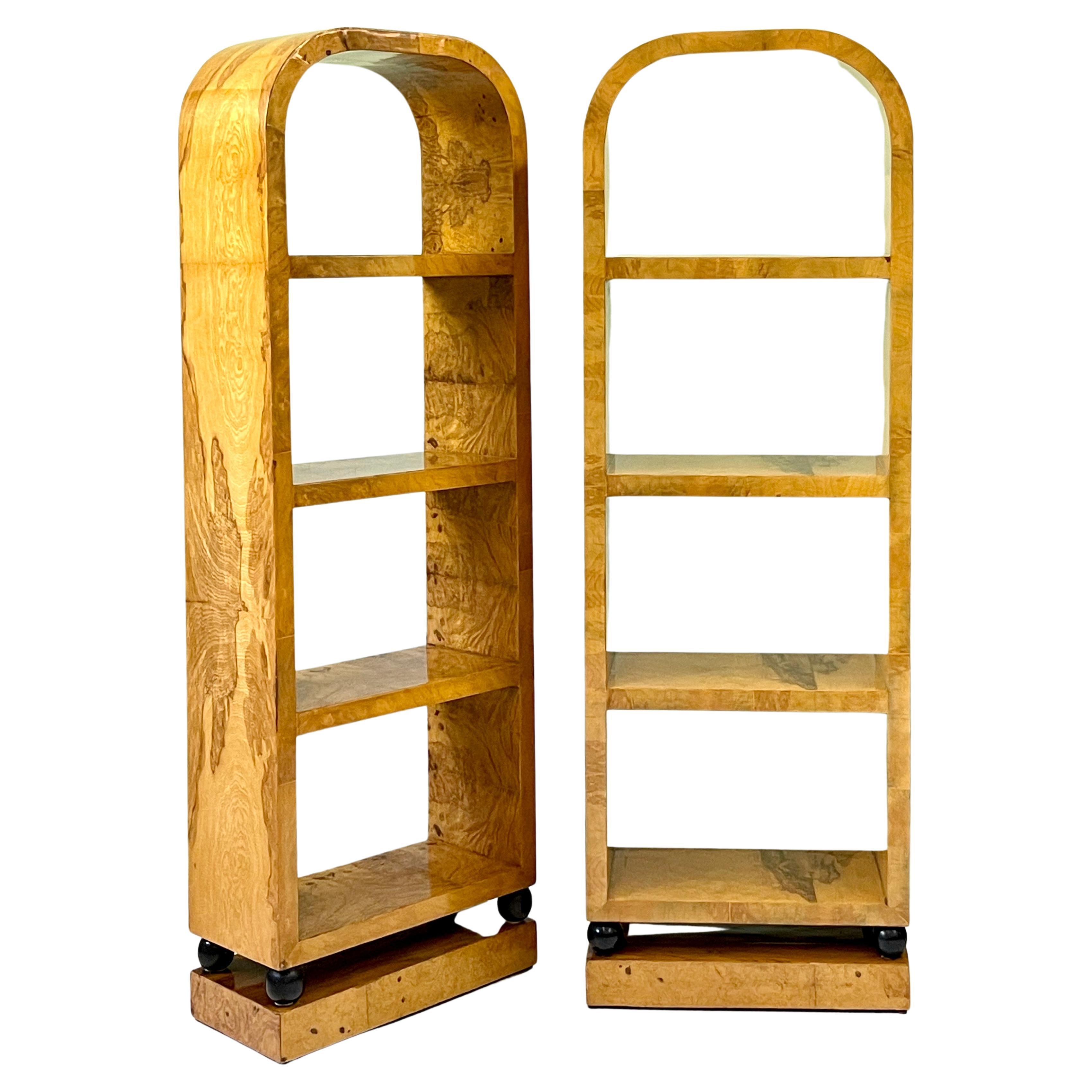 Wonderful pair of 20th Century Italian bookcases beautifully constructed of birch burl veneer in the style of Art Deco. The arched-top open bookcases are finished on all sides, contain three floating shelves, and are raised on ebonized spheres above
