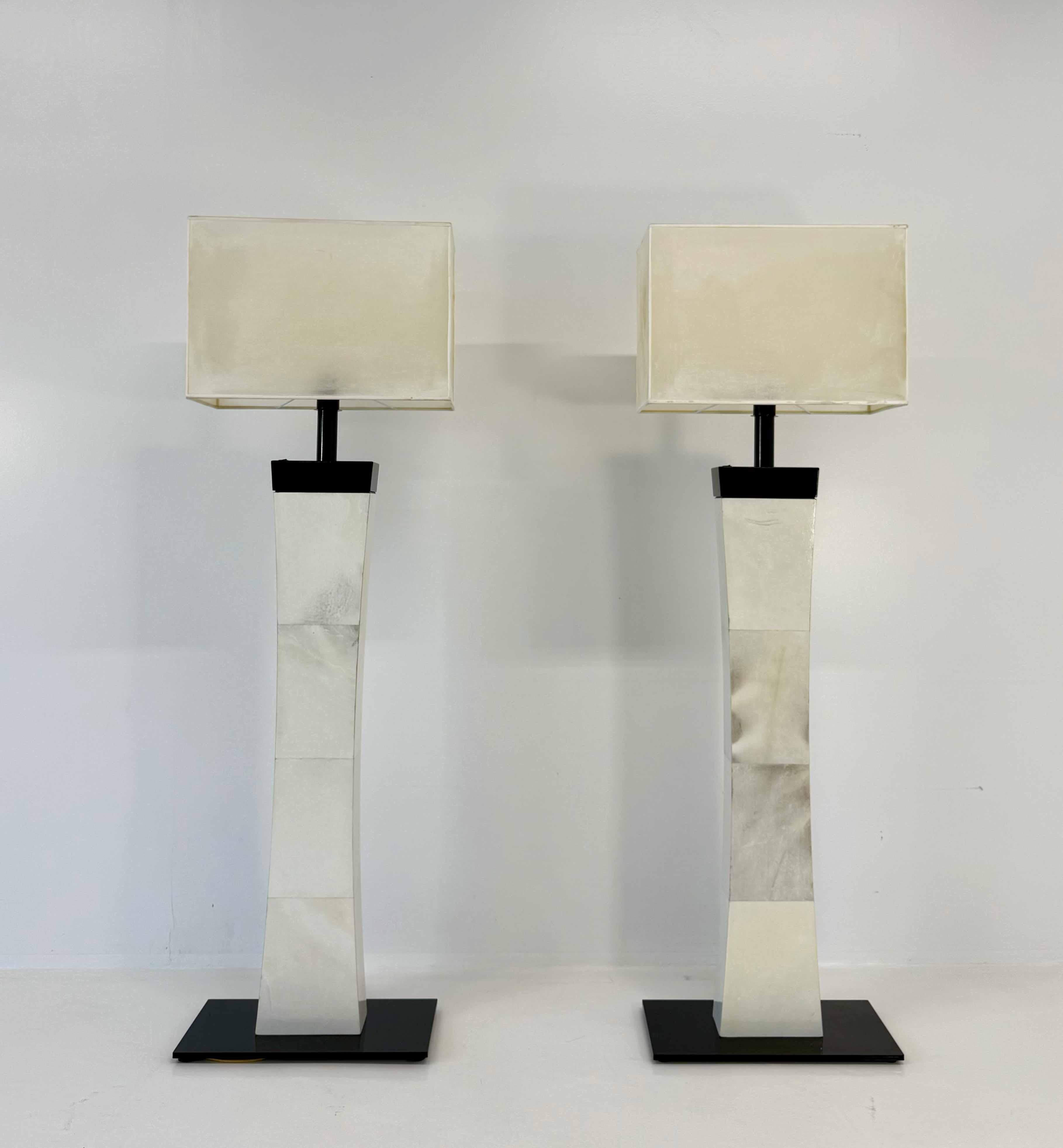 Pareja de lámparas de pie italianas de estilo Art Decó de la década de 1980, con elegantes columnas cubiertas de pergamino, pantallas de papel pergamino y bases negras. El diseño alto y vertical recuerda el equilibrio geométrico del Art Déco,