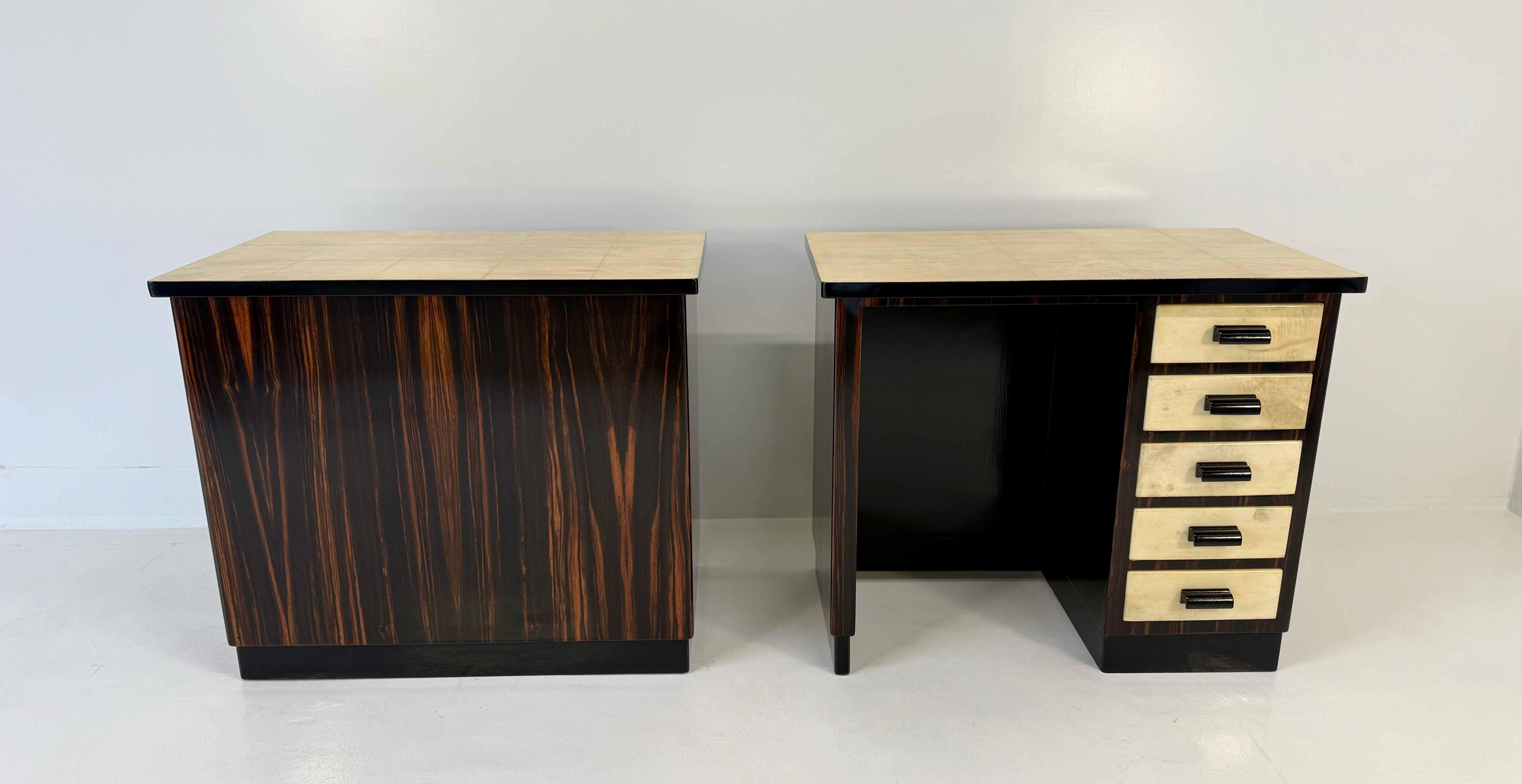 Elegance coppia di scrivanie gemelle in stile Art Déco italiano, anni '40.
Il design raffinato è caratterizzato da strutture in legno di Macassar arricchite da superfici in pergamena sui piani e sui cassetti. Il ritmo geometrico è ulteriormente