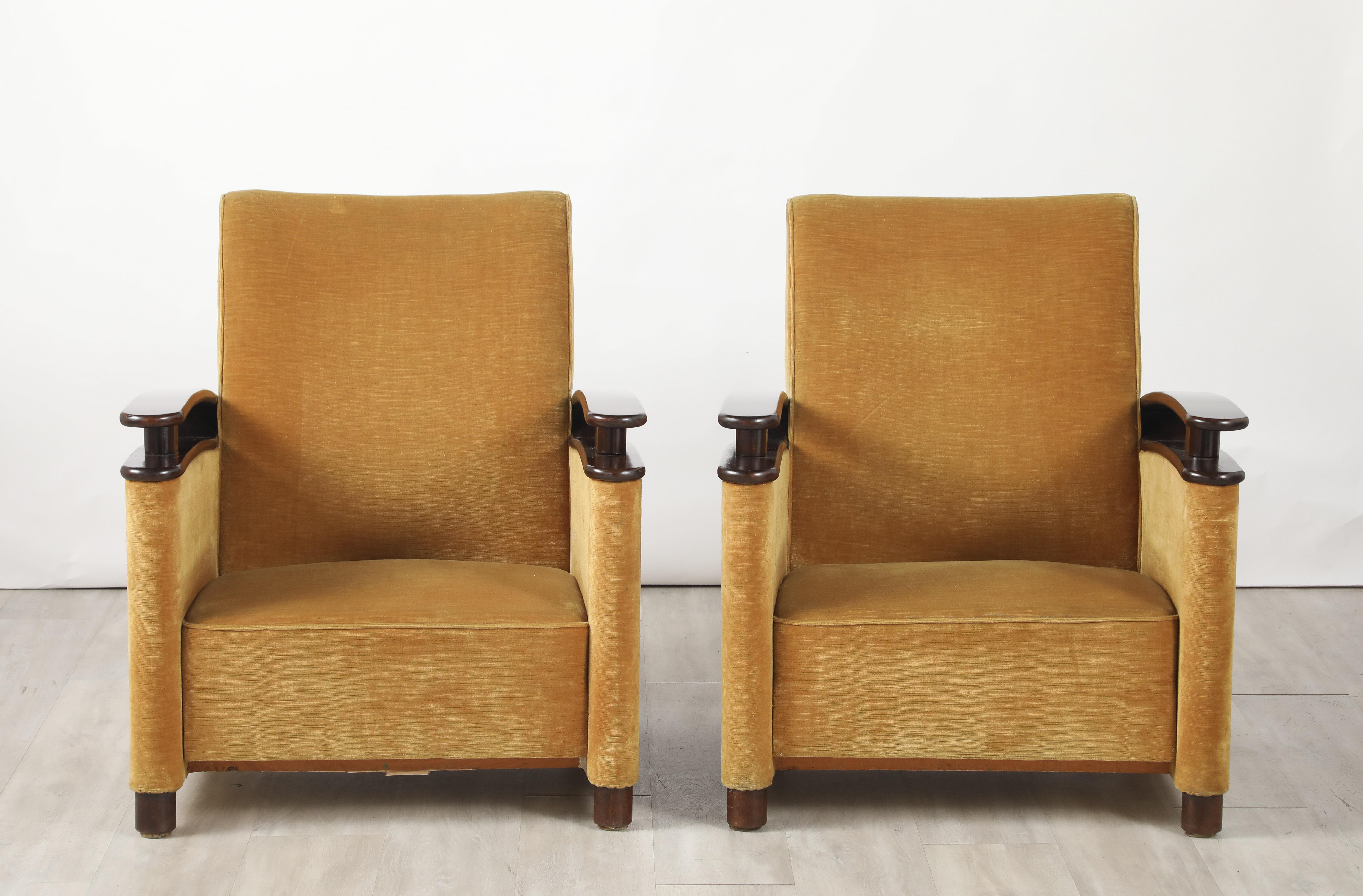 Un llamativo y elegante par de sillones Art Decó del norte de Italia; la forma altamente escultural se ve realzada por los elegantes reposabrazos curvados de nogal con un diseño de obra abierta, que se extienden desde la parte delantera hasta la