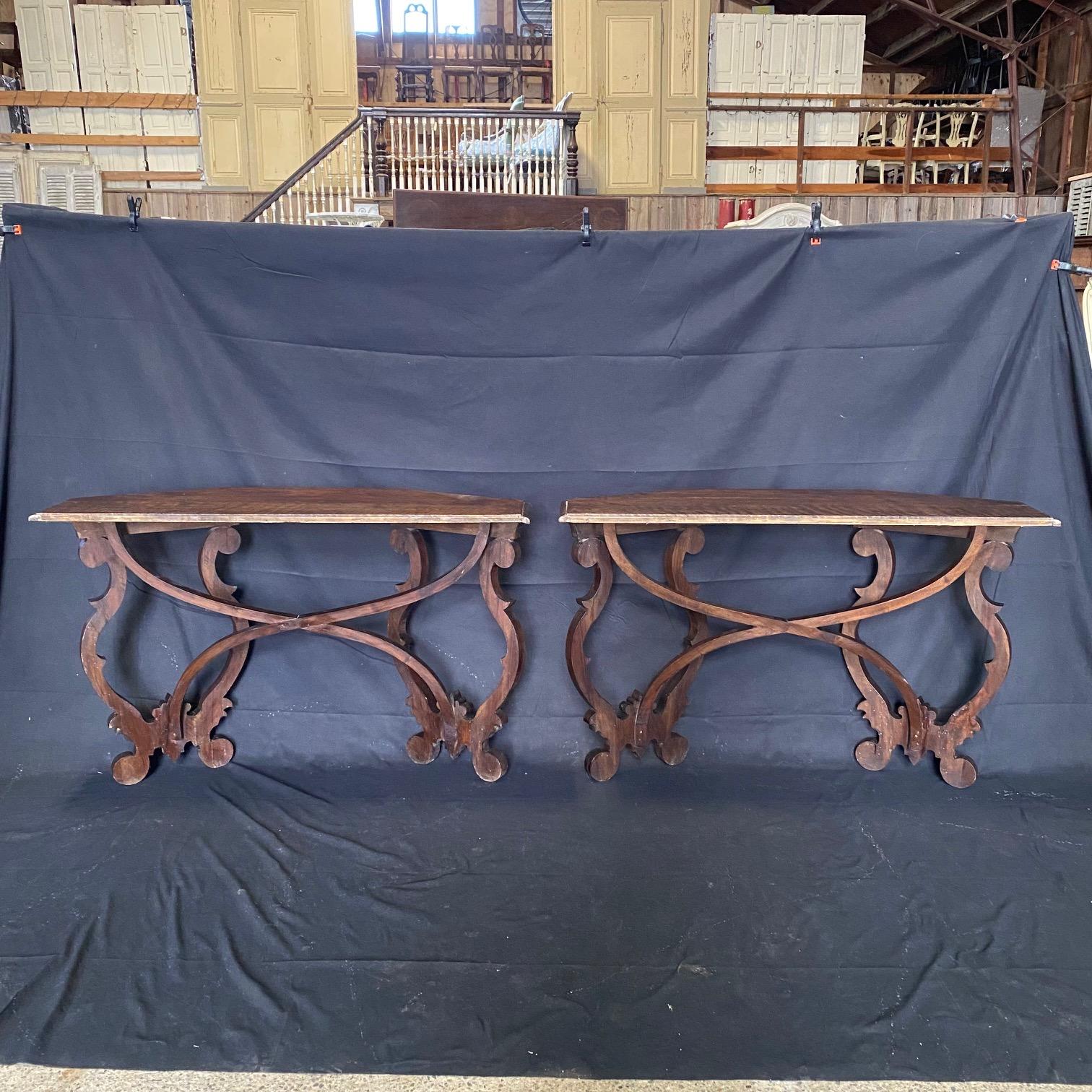 Pair of supremely elegant Italian Baroque early 18th Century demilune console tables, with unusual, elaborate design, the D shaped top with molded edge over scroll legs with stunning curved x-shaped conforming stretchers. Could also serve as sofa