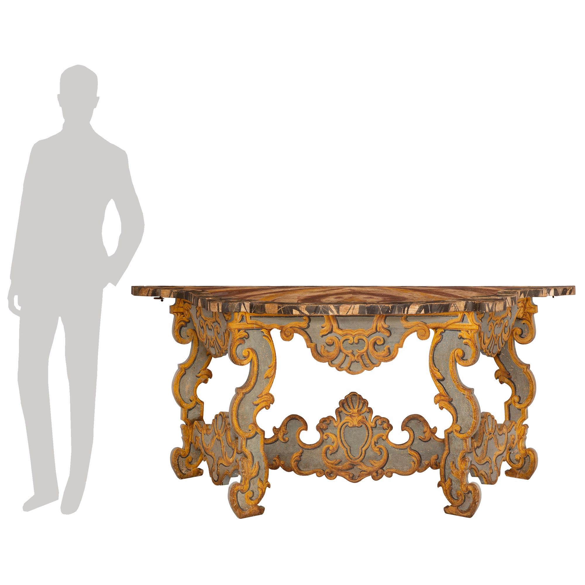 A sensational and elaborately decorated pair of Italian early 18th century Baroque Period patinated wood consoles/center table. The freestanding consoles/center table are raised by four handsome scrolled patinated legs which are all joined by side