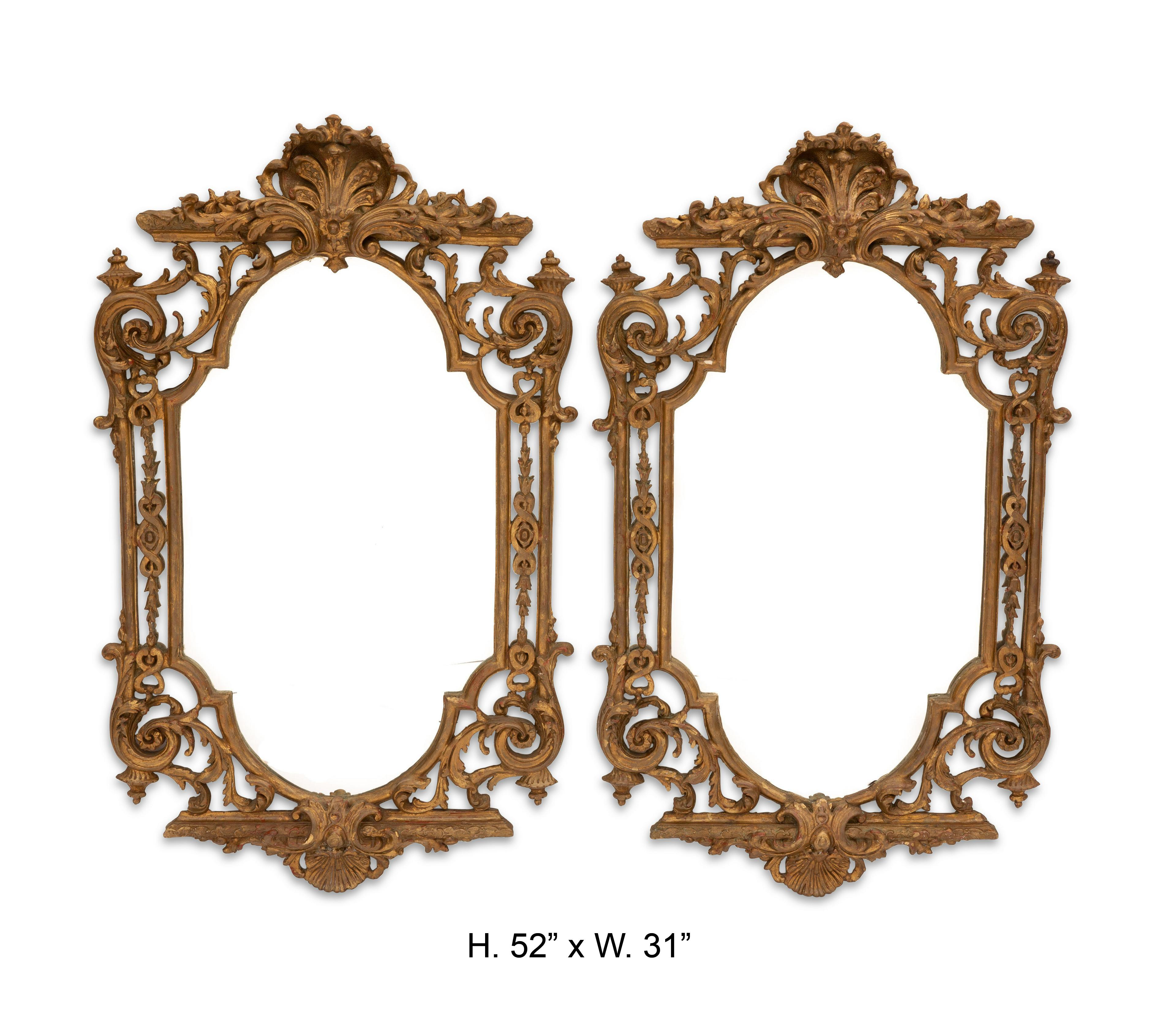 Impressive pair of Italian Baroque style carved giltwood and gesso mirrors. Intricately carved shell cresting encircled with foliage top over a pierced scrolling giltwood frame with a shaped mirror plate, circa 1900.

The fact that these mirrors