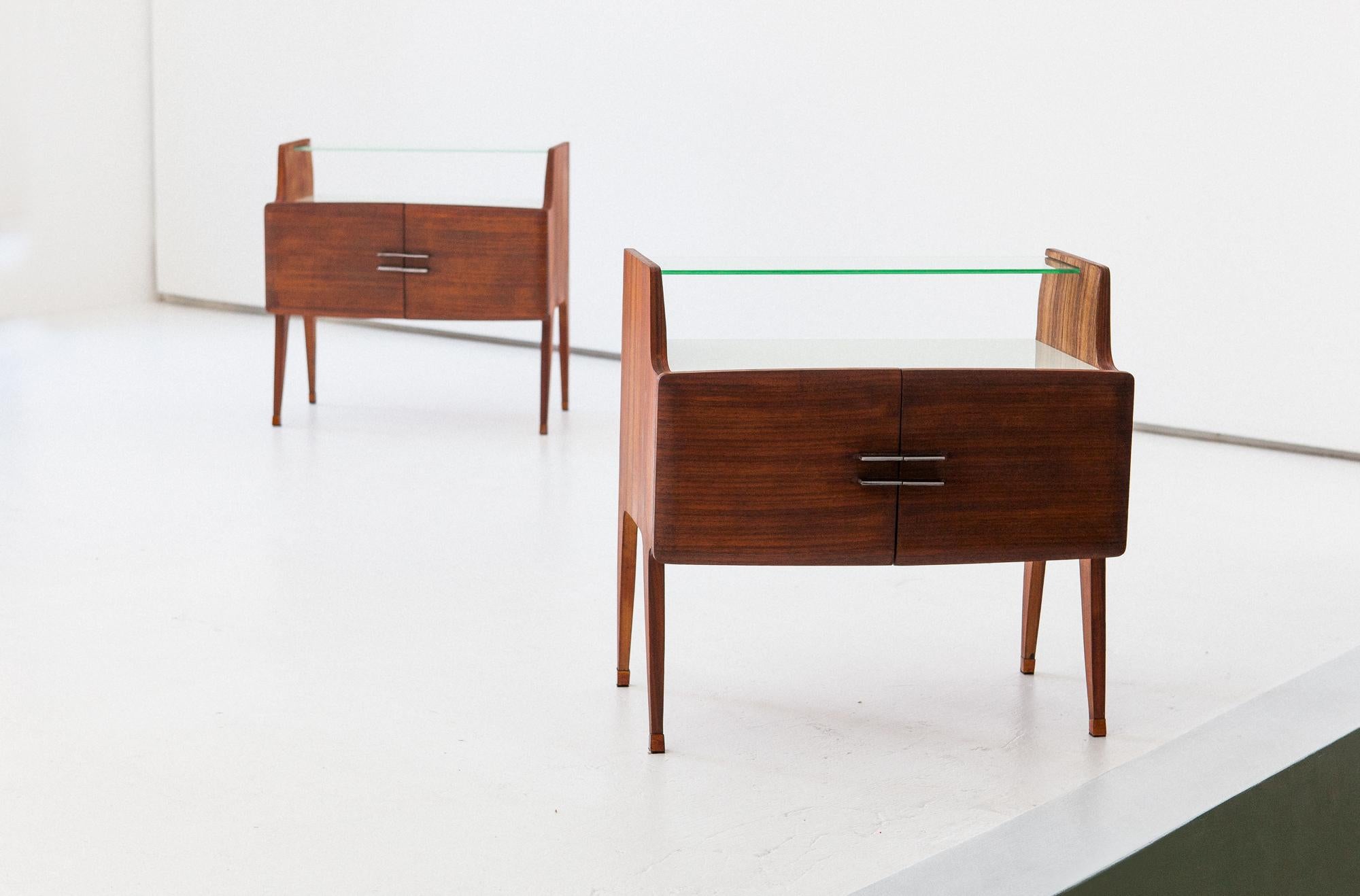 Set of two nightstands, manufactured in Italy in 1950s
These two side tables are teak veneer with iron handles , brass browned feets and white retrolacquered glass .
Airy and modern design, rich in details, elegant and precious.

Completely