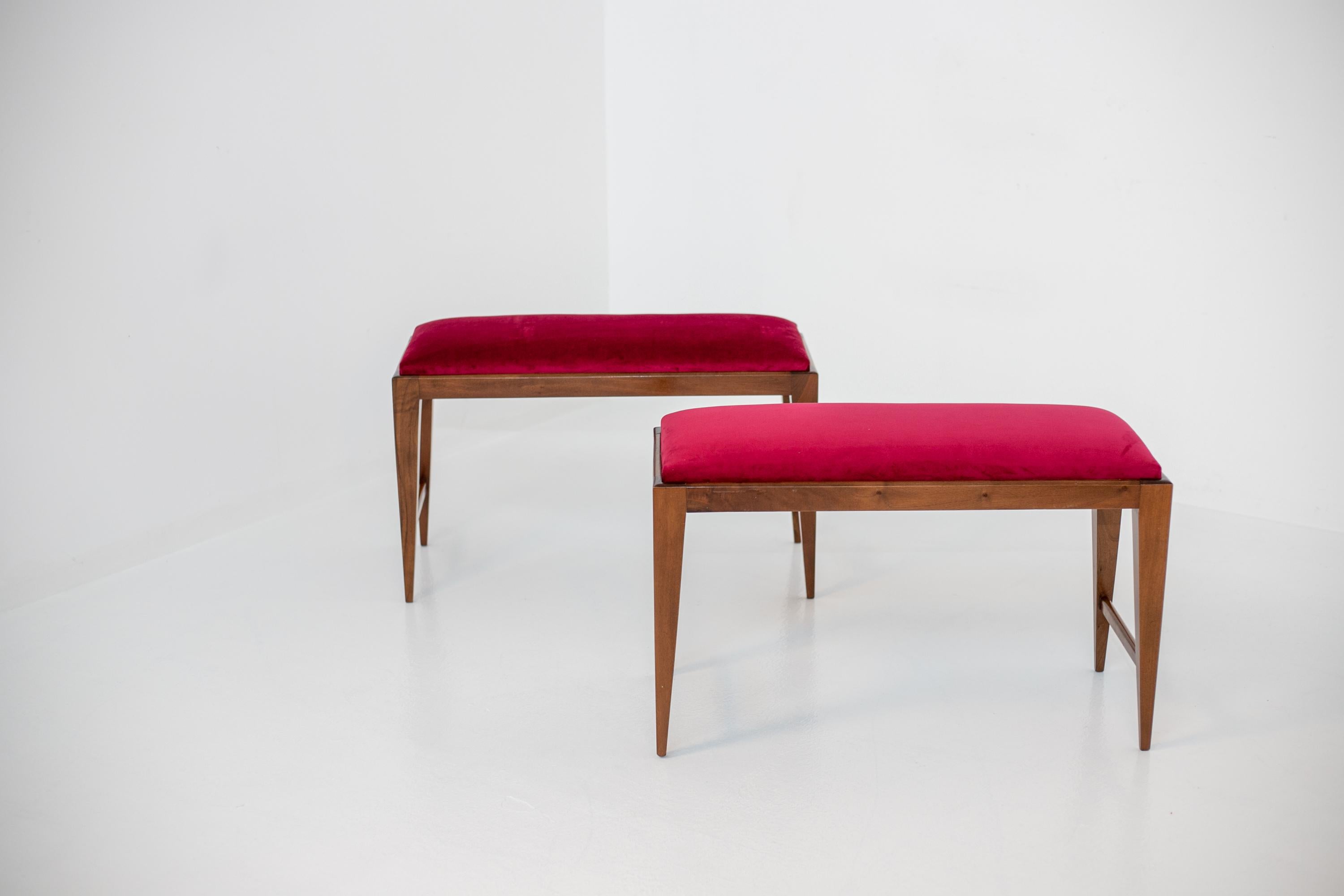Elegant pair of restored 1950's Italian stools. The pair of benches have been restored in dark red velvet fabric. Beautiful wood shapes , in fact they almost recall the Pontian design with pyramidal wooden legs. The structure is made of walnut wood