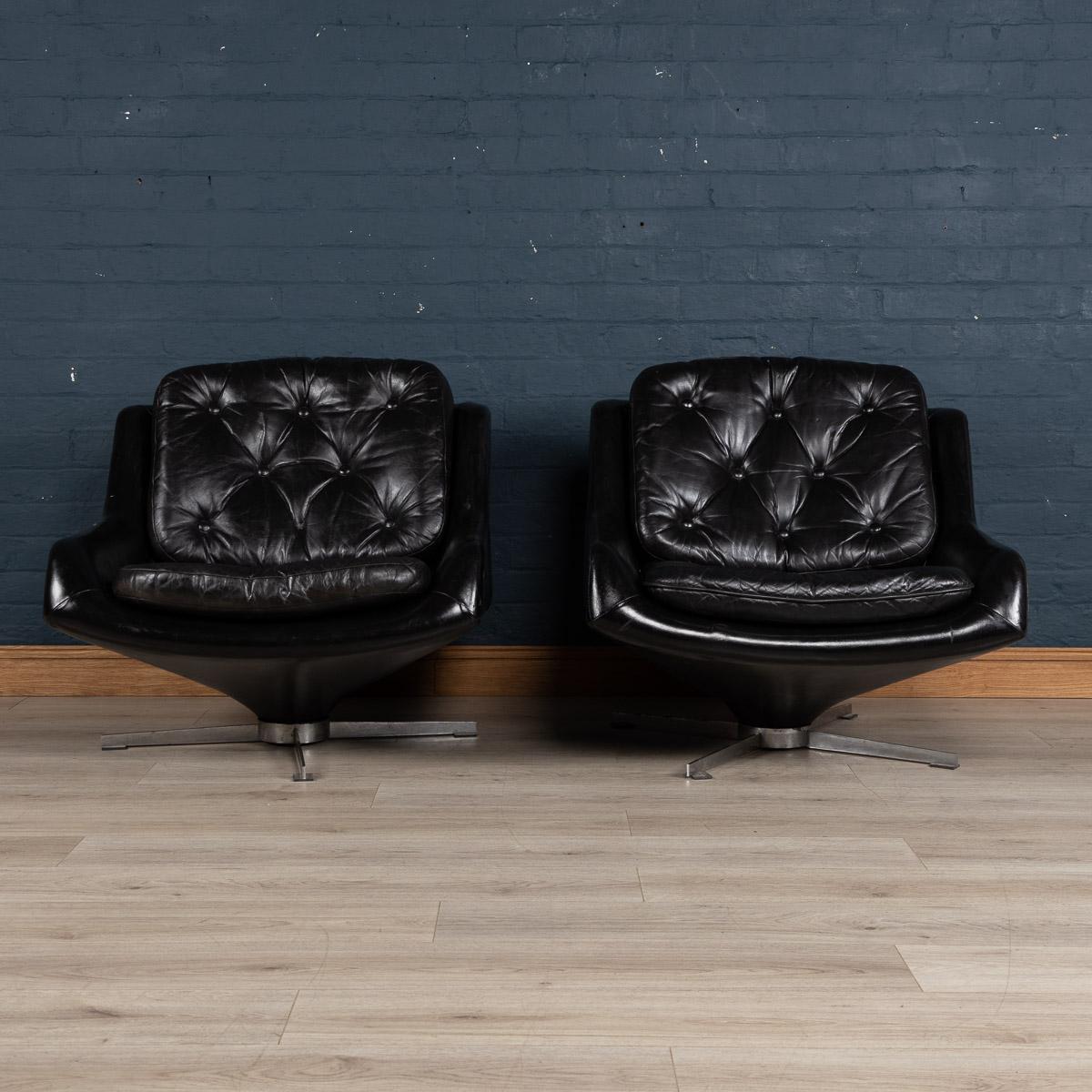A wonderful pair of lounge armchairs with a swivel mechanism, probably Italian. The fiberglass structure has been covered in superb quality black leather and is supported by a chromed foot. On top rests loose black leather buttoned back and seat