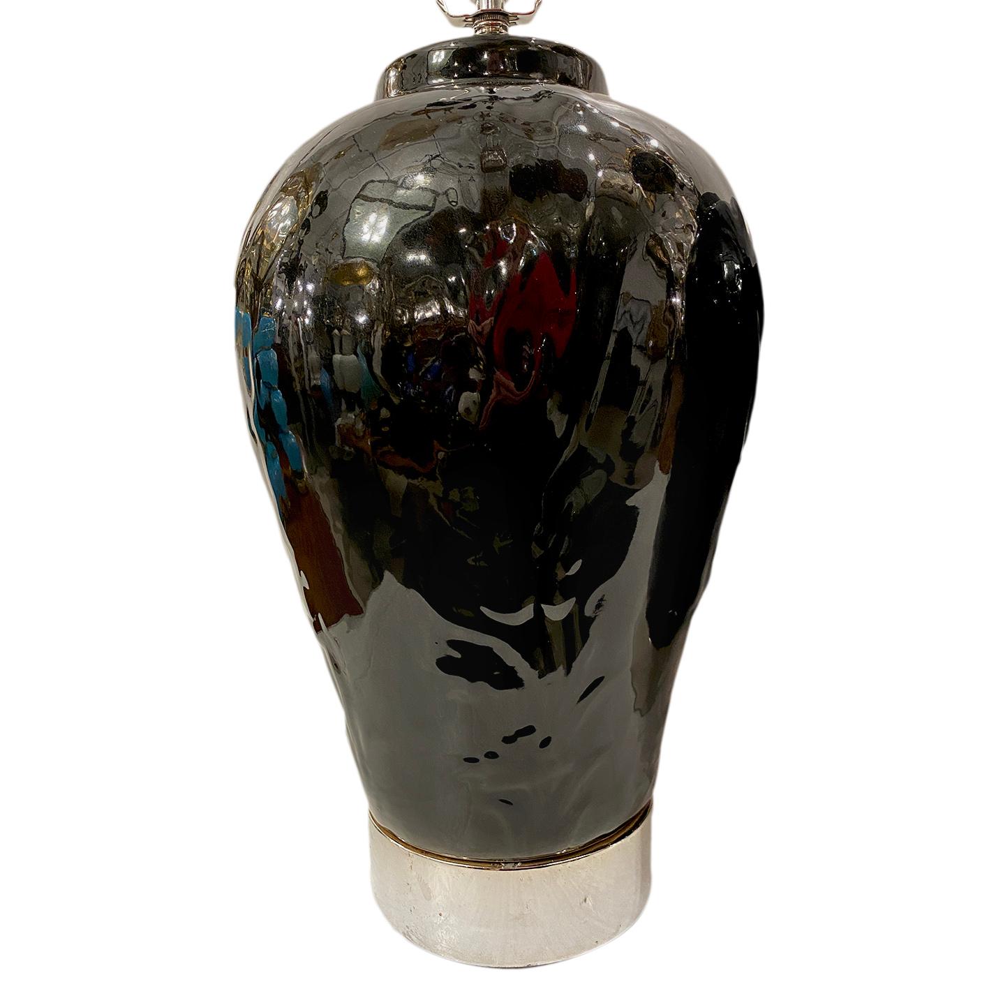 A pair of circa 1950s black porcelain table lamps with silver plated bases.

Measurements:
Height of body 18”
Width 11”.