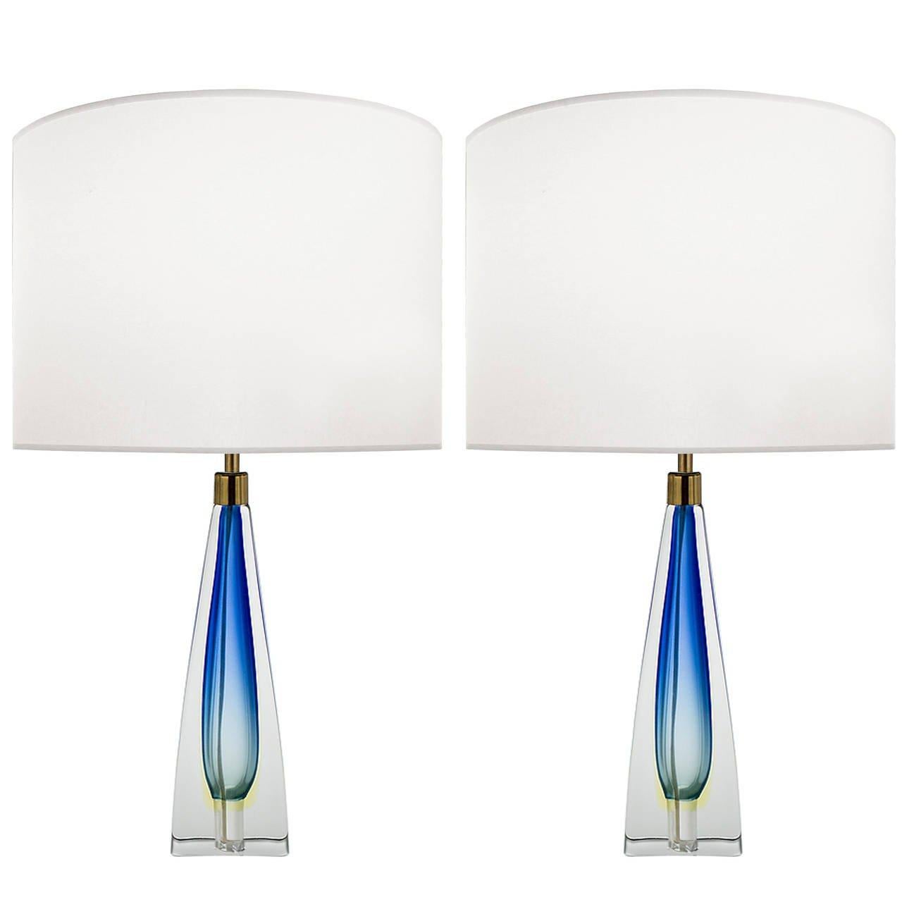 A pair of blue glass lamps with thick clear casing and brass hardware.

Italian, circa 1958

Lamp shades are not included.

Lamp shades are available in: White or Ecru Linen Color.


 