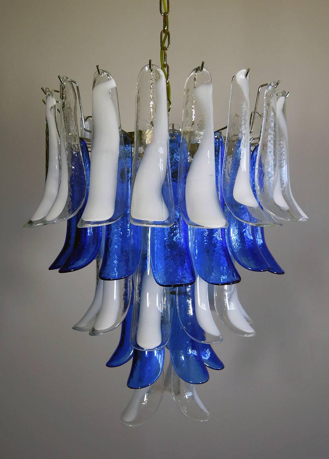 Huge Italian vintage Murano chandelier made by 52 glass petals with a chrome frame. The glasses have two colors:
31 glass petals transparent and white “lattimo” +21 glass petals blue color.
available 4 pairs.
Period: 1970s-1980s.
Dimensions: