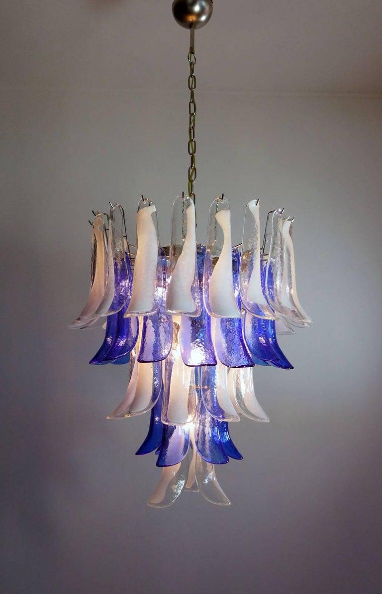 Huge Italian vintage Murano chandelier made by 52 glass petals with a chrome frame. The glasses have two colors:
31 glass petals transparent and white “lattimo” +21 glass petals blue color.
available 4 pairs.
Period: 1970s-1980s.
Dimensions: 55.10