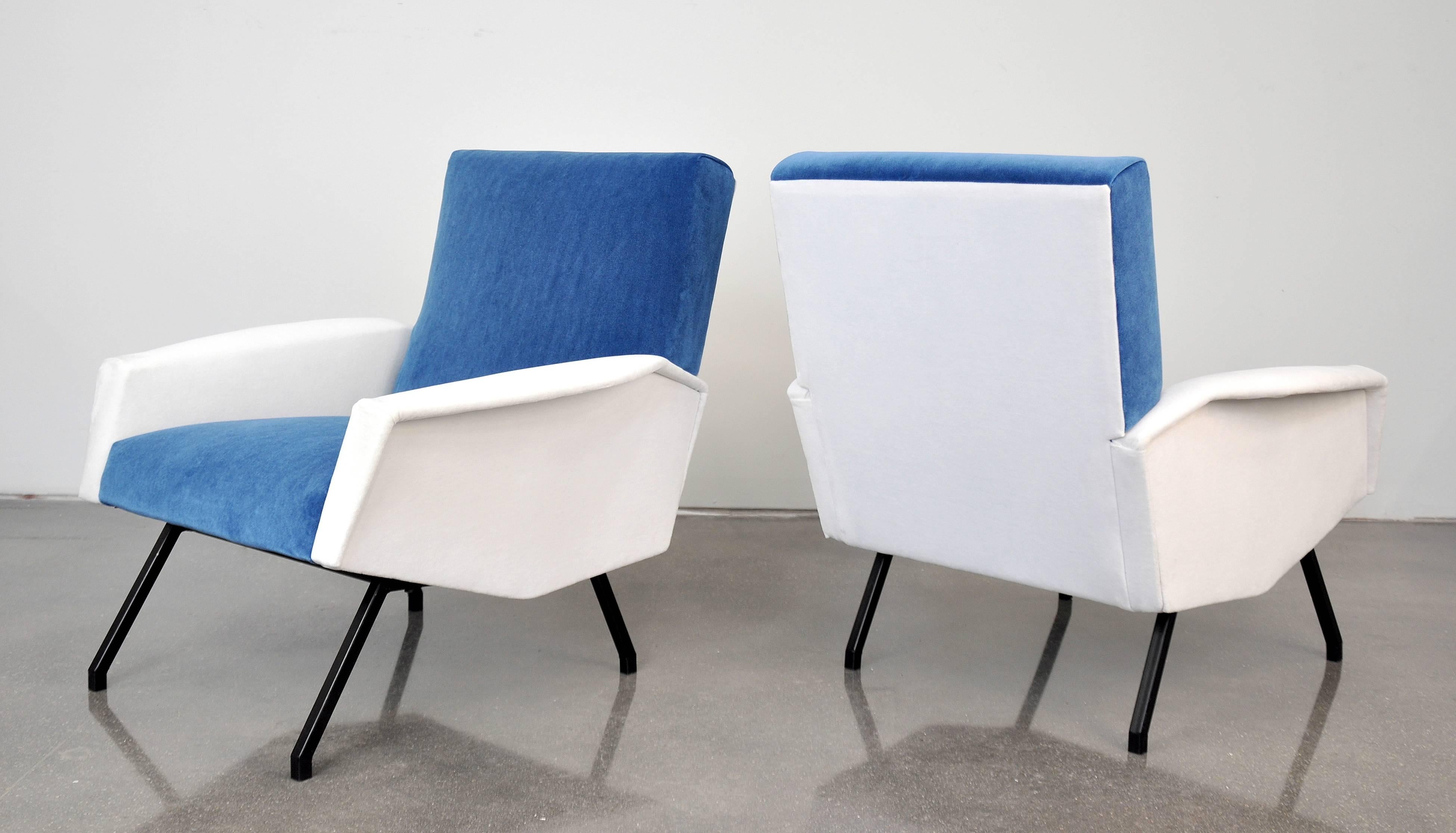 A gorgeous pair of Mid-Century Modern poltrone or club chairs with black lacquered iron legs, in the style of Gio Ponti, made in Italy in the 1950s. The armchairs have been recovered in an azure sky or light sapphire blue and white velvet. They are