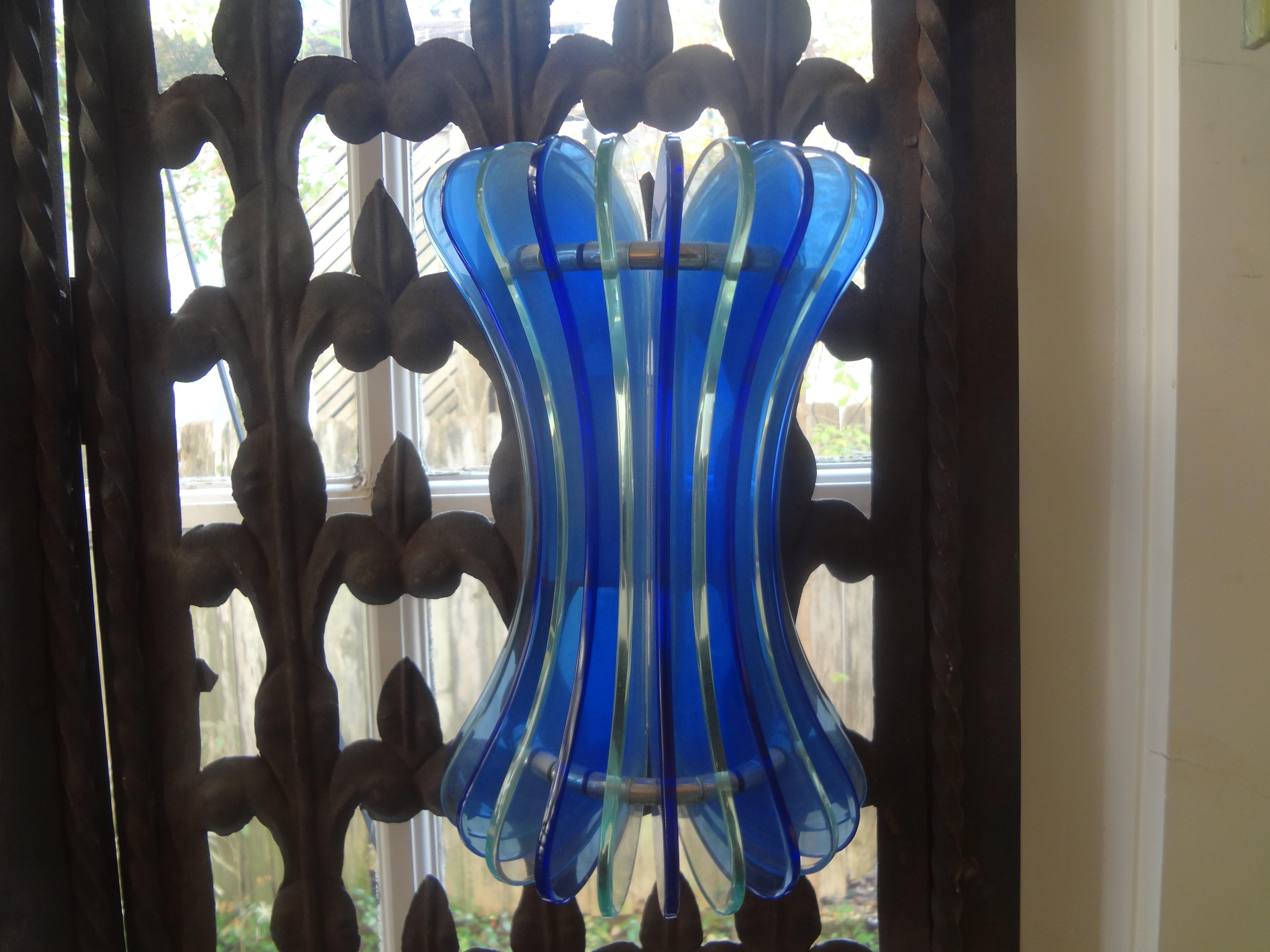 Pair of Italian blue glass sconces by Veca.
This stunning pair of Italian sconces have alternating blue and clear glass panels mounted on chromed steel frames.
Each sconce has been newly wired with two new sockets.