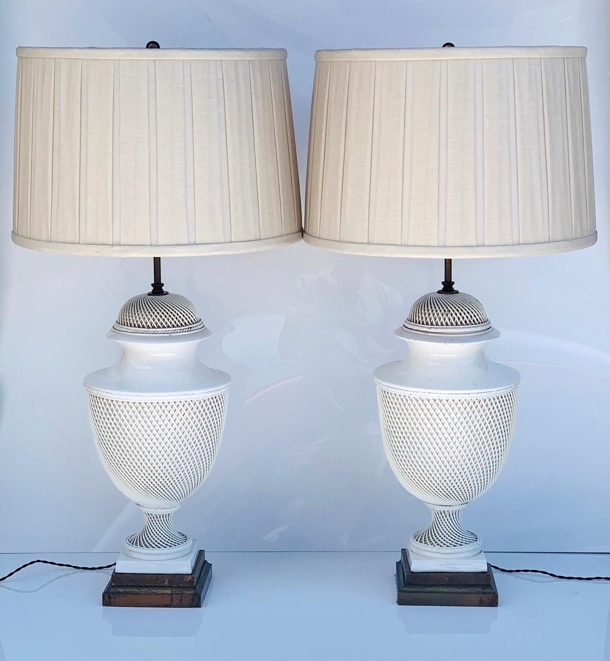 Stunning pair of elliptical braided lattice ceramic Italian lamps with a brass and wood base.

The lamps are beautifully crafted, the shades are in good condition and perfect to be used.

The brass rod holding the shades is height adjustable and