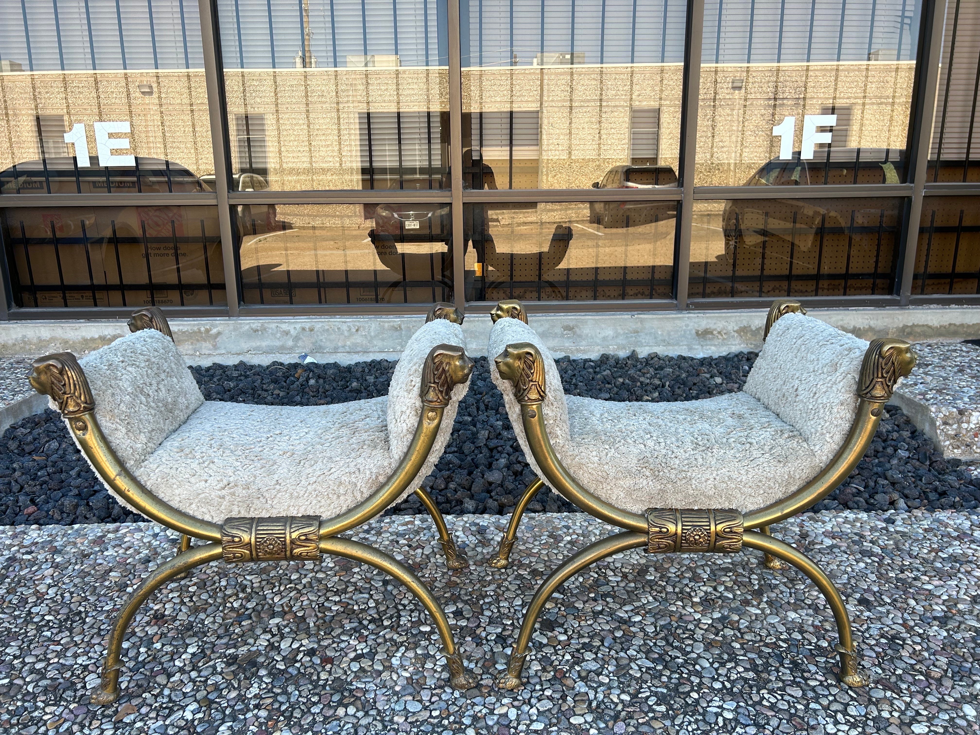 Pair Of Italian Brass Curule Benches With Lions Heads.
This great pair of antique Italian brass curule benches feature 4 lion's heads and paw feet. They have been taken down to the frame and newly upholstered in plush neutral lambs wool type