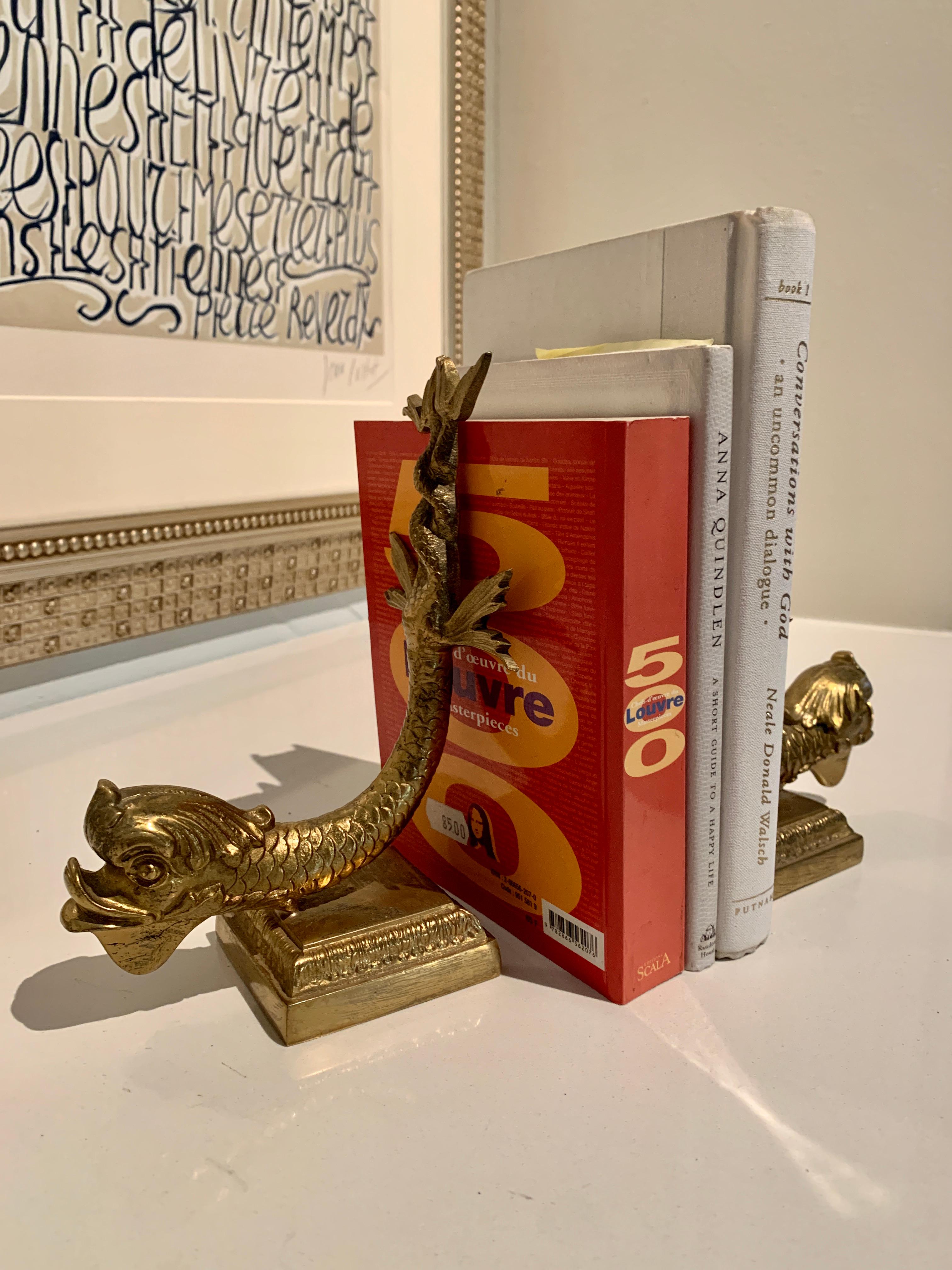 Pair of solid brass Dolphin serpent bookends. A compliment to any bookshelf or desk. Classic Mid Century figures, the brass weight and style make them a very sophisticated pair. Made in Italy.