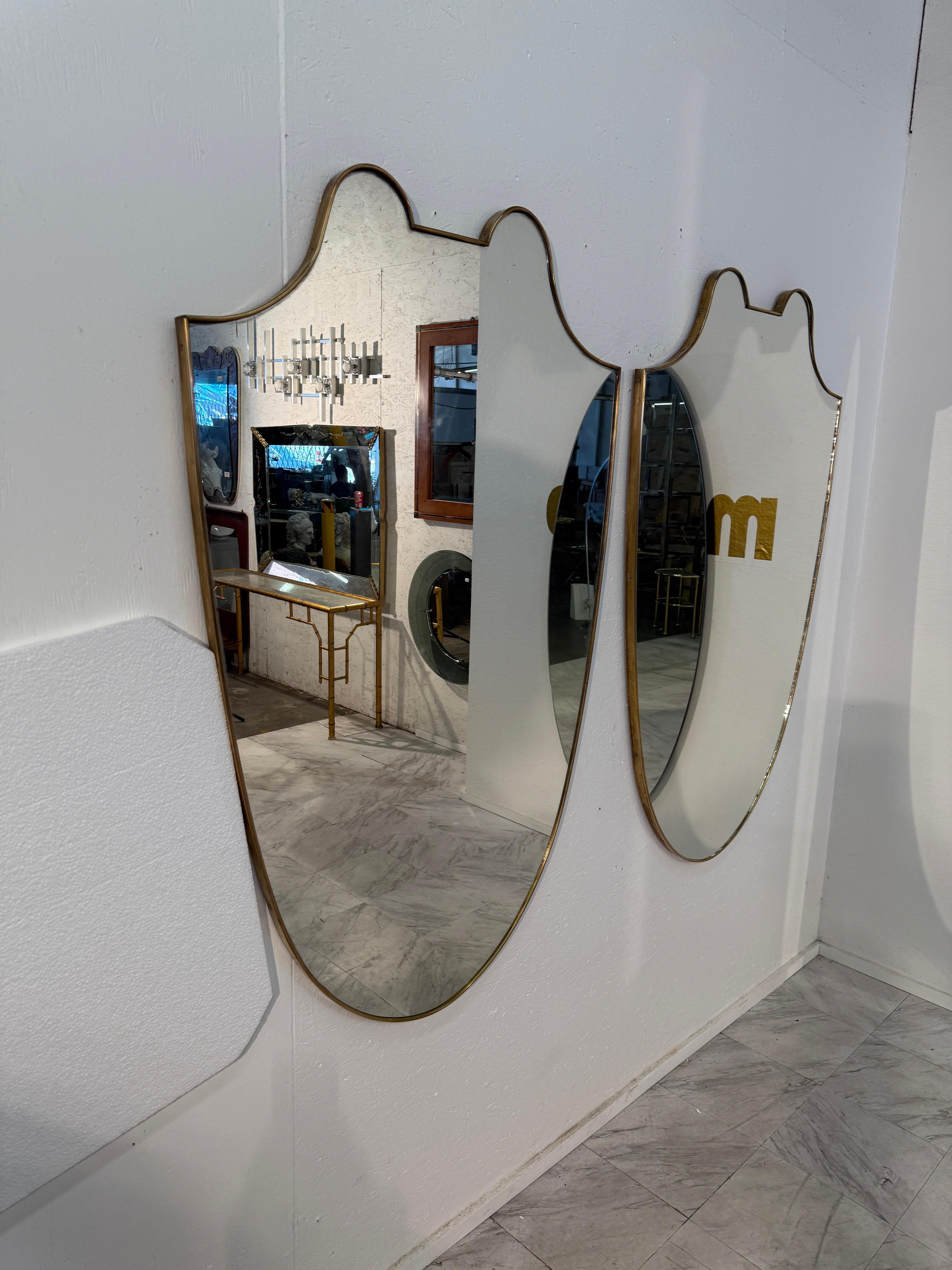 Moderno Coppia di specchi da parete italiani con cornice in ottone a forma di scudo, anni '50 in vendita