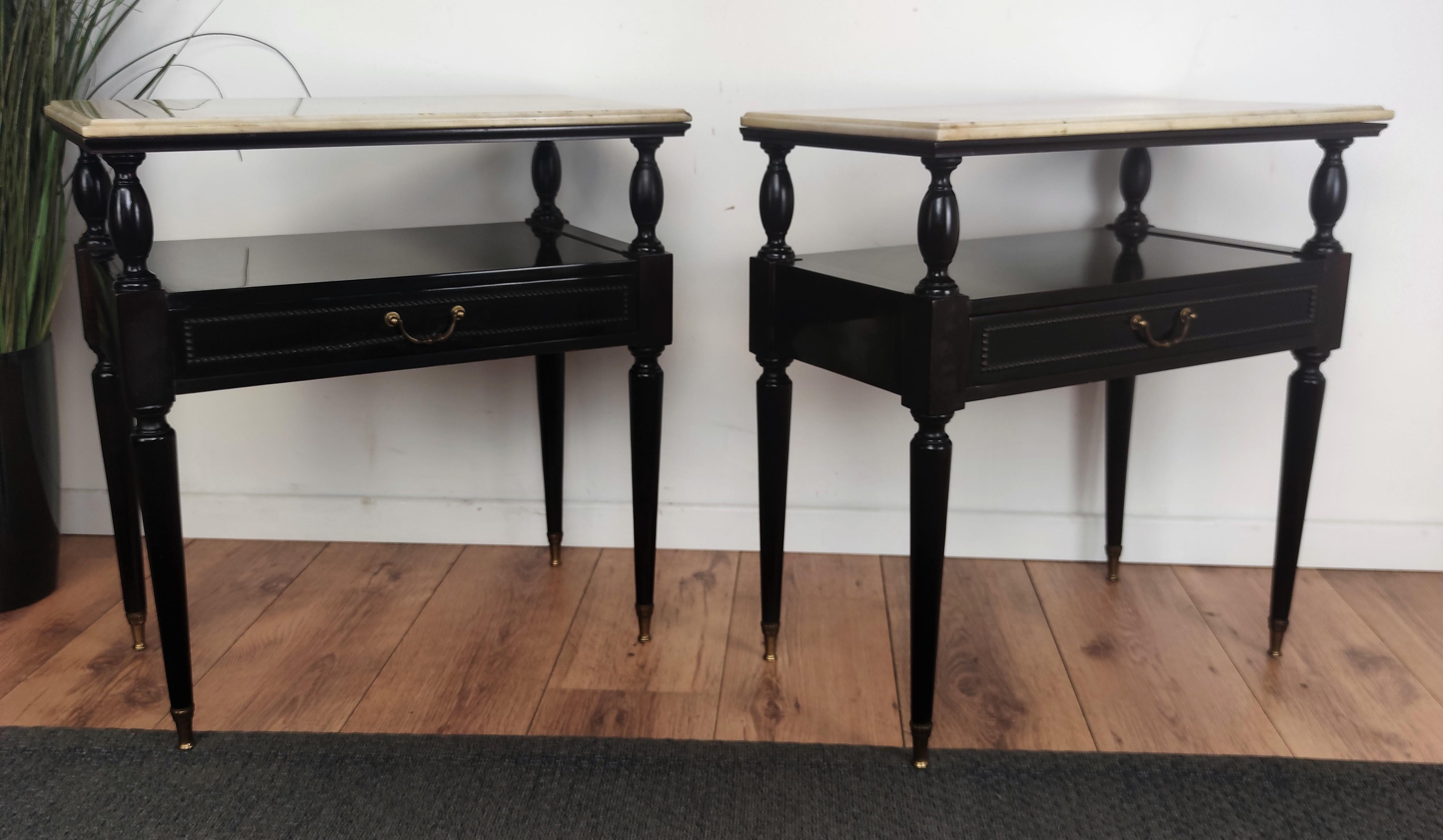 Very elegant and refined Italian 1950s neoclassical pair of night stands bed side tables with black lacquered wooden structure, decorated front drawer and white marble top with brass details. Those side tables or nightstands make a great look in any