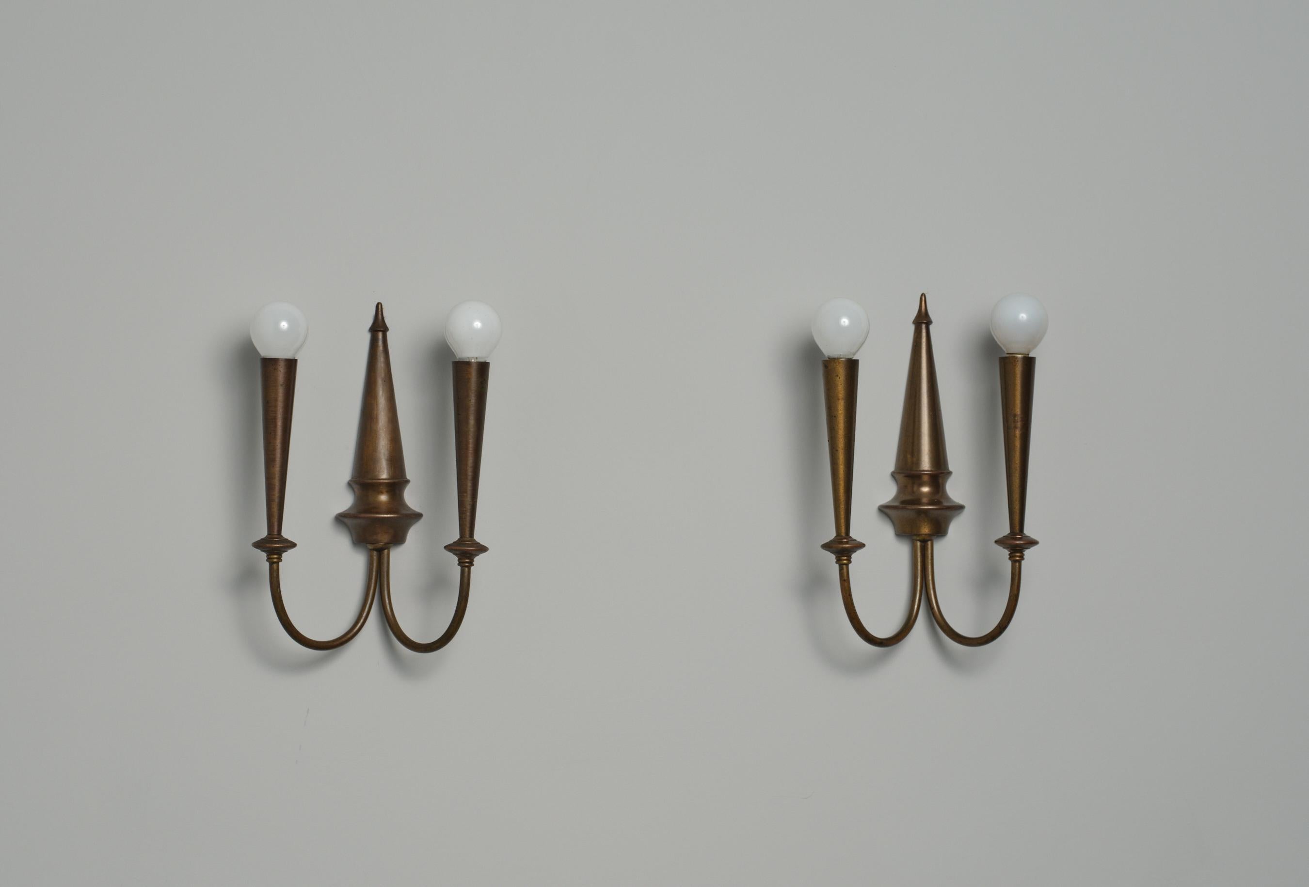 Questa coppia di applique, progettata e prodotta in Italia negli anni '50, presenta un design pulito ed elegante realizzato interamente in ottone. Le lampade da parete presentano una patina e un'ossidazione invecchiate che aggiungono carattere e