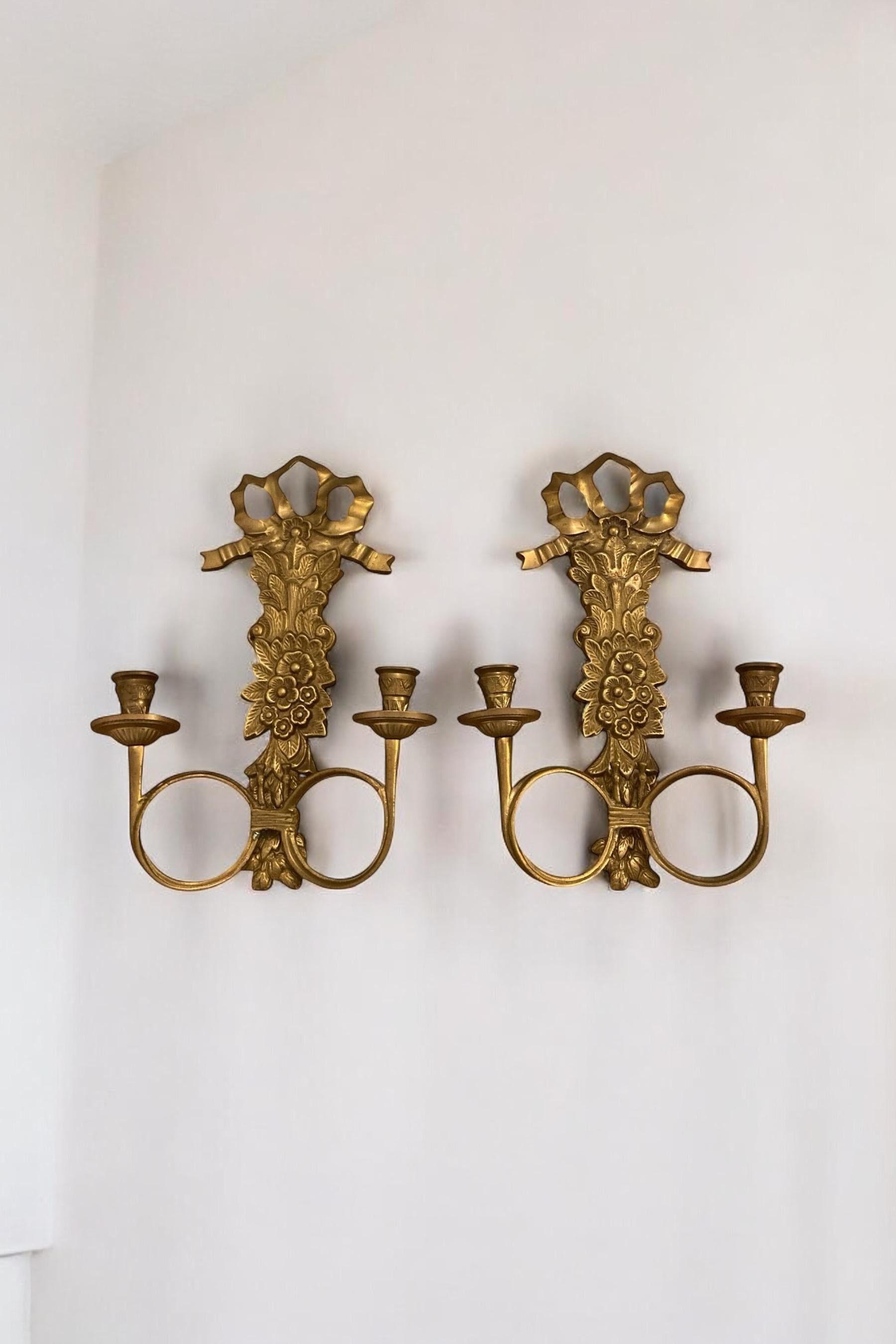 Pareja de apliques de latón italiano, candelabro, lazo con detalle floral con dos soportes.

H: 33 cm

An: 23 cm

D: 8 cm