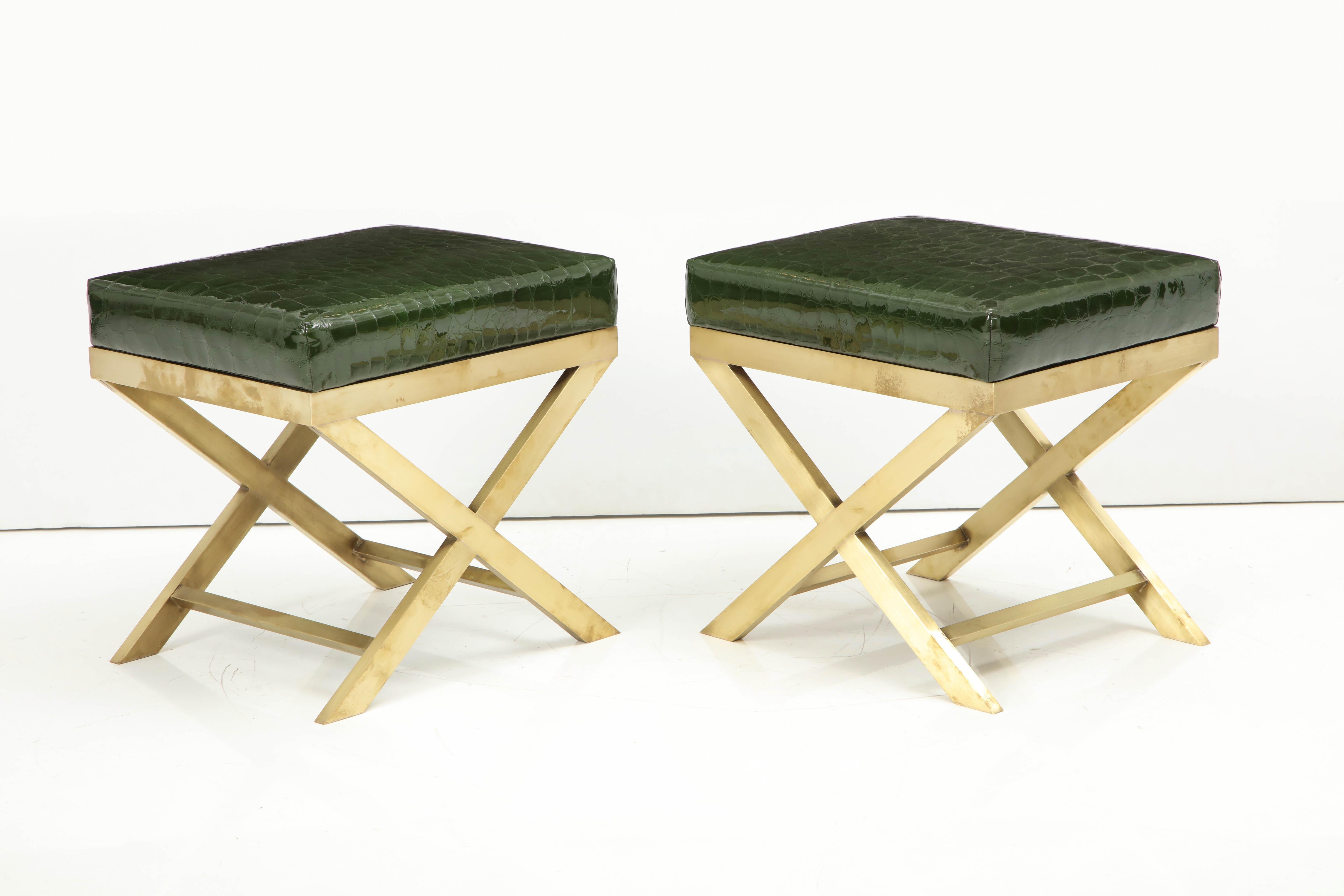 These super chic benches feature a brass base with an eye-catching green faux crocodile patent leather. This duo, perfect as extra seating or as a perch for books, will add a touch of style to any room.