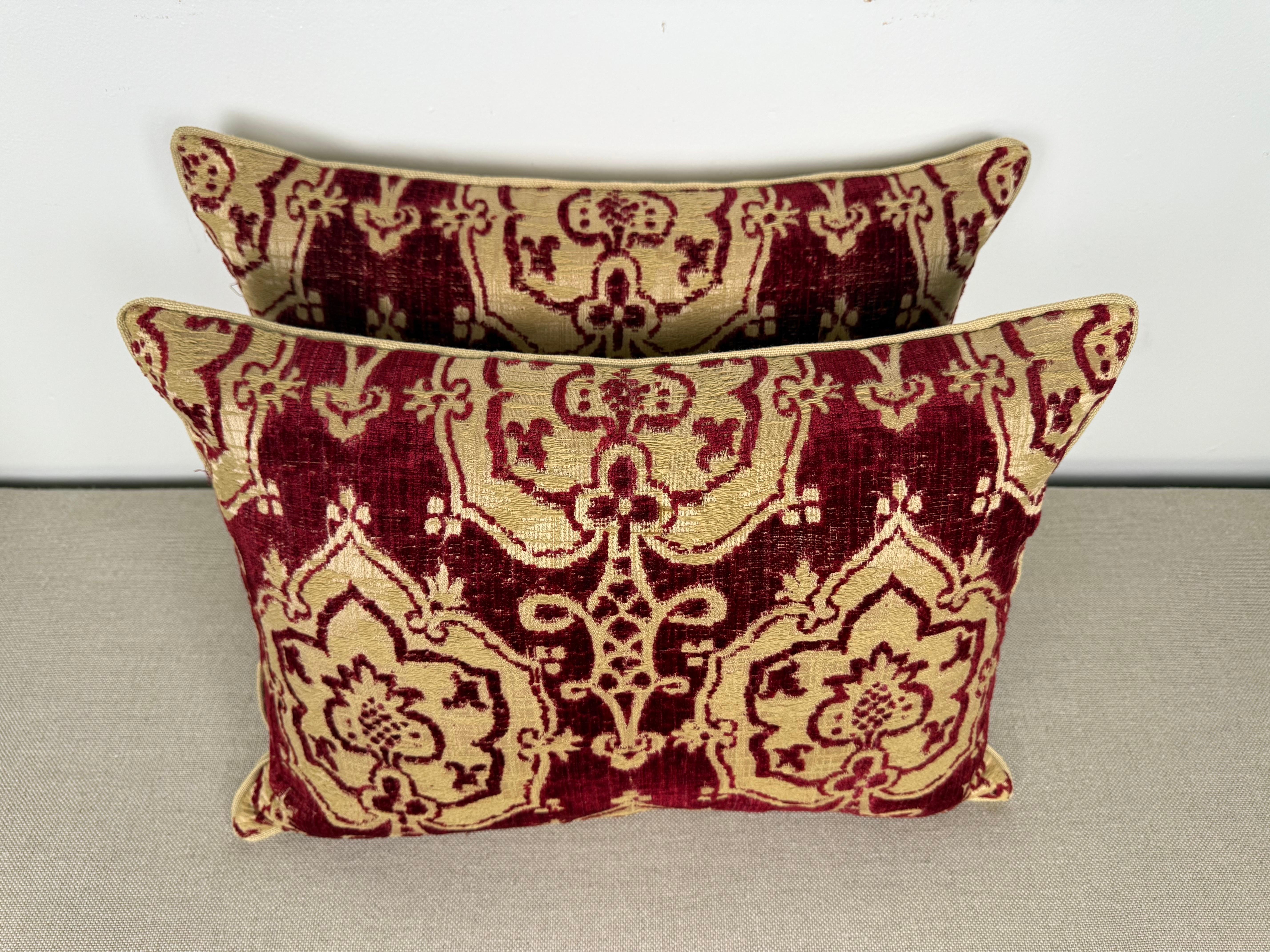 Questi cuscini sono realizzati in broccato italiano antico e presentano un design ricco di texture in una lussuosa tavolozza di rosso rubino e oro. Il motivo del broccato mette in risalto un motivo floreale ornato e a scorrimento con una texture di