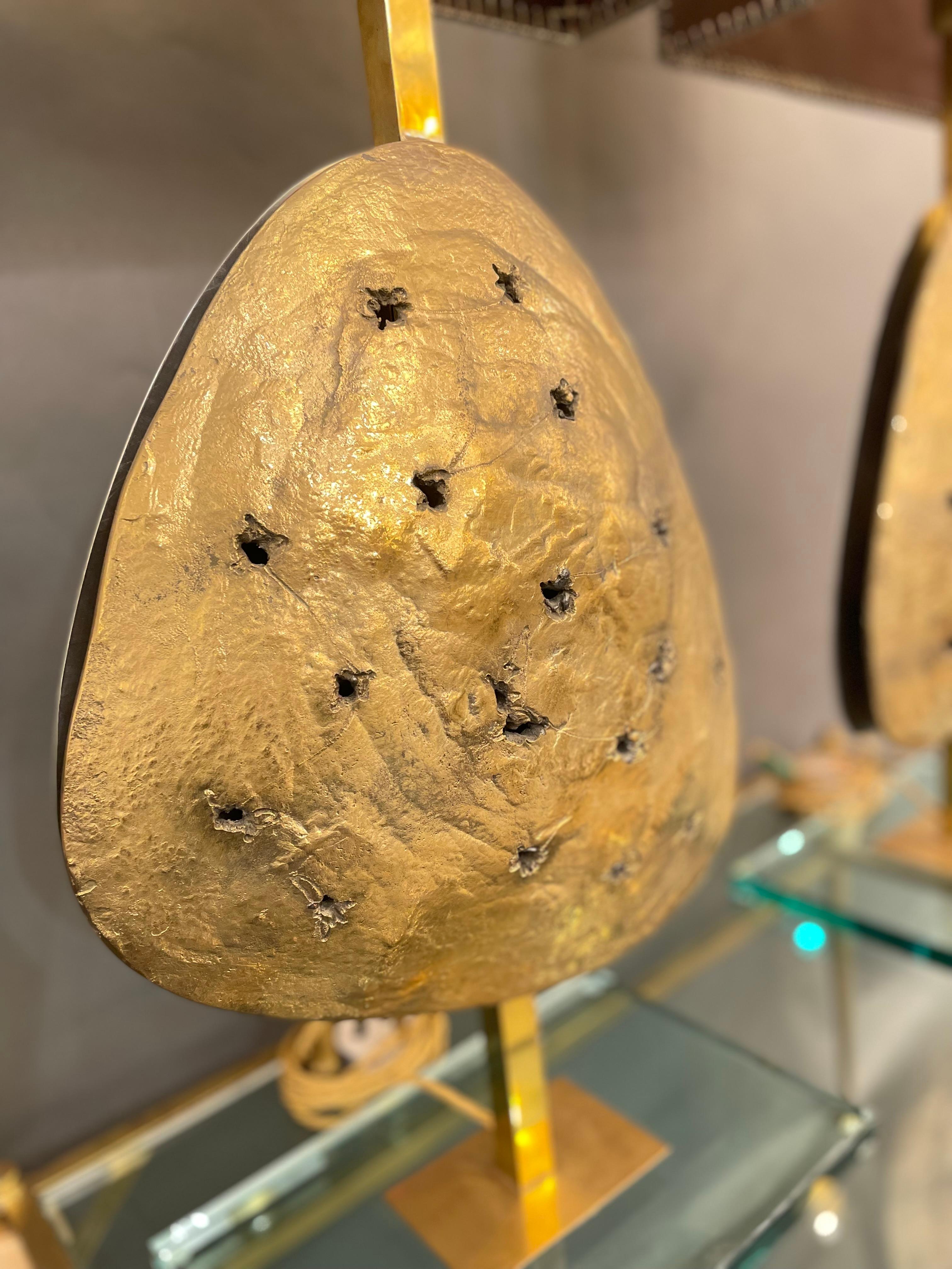 A unique pair of Italian bronze table lamps, lighted abstract sculptures entirely cast in bronze, presenting a very interesting shield-shape front plaque enclosing fissures in the body, Attributed to Angelo Brotto, circa 1970.