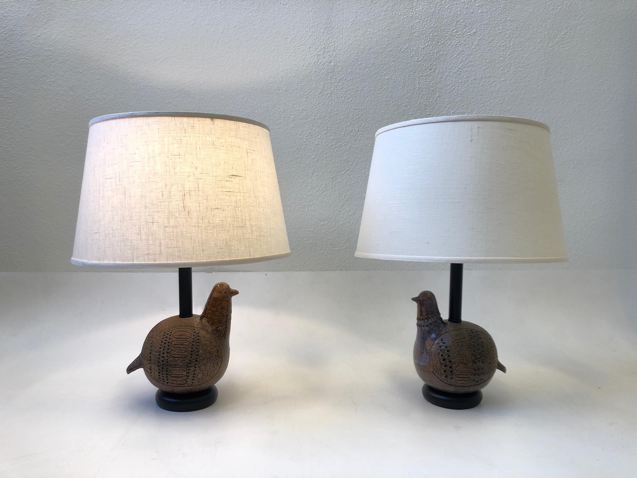 Pair of Italian brown ceramic birds and black lacquered table lamps design in the 1970s by Aldo Londi for Bitossi. Newly rewired with brass hardware and new vanilla linen shades. The bird are handmade, so they are not exactly the