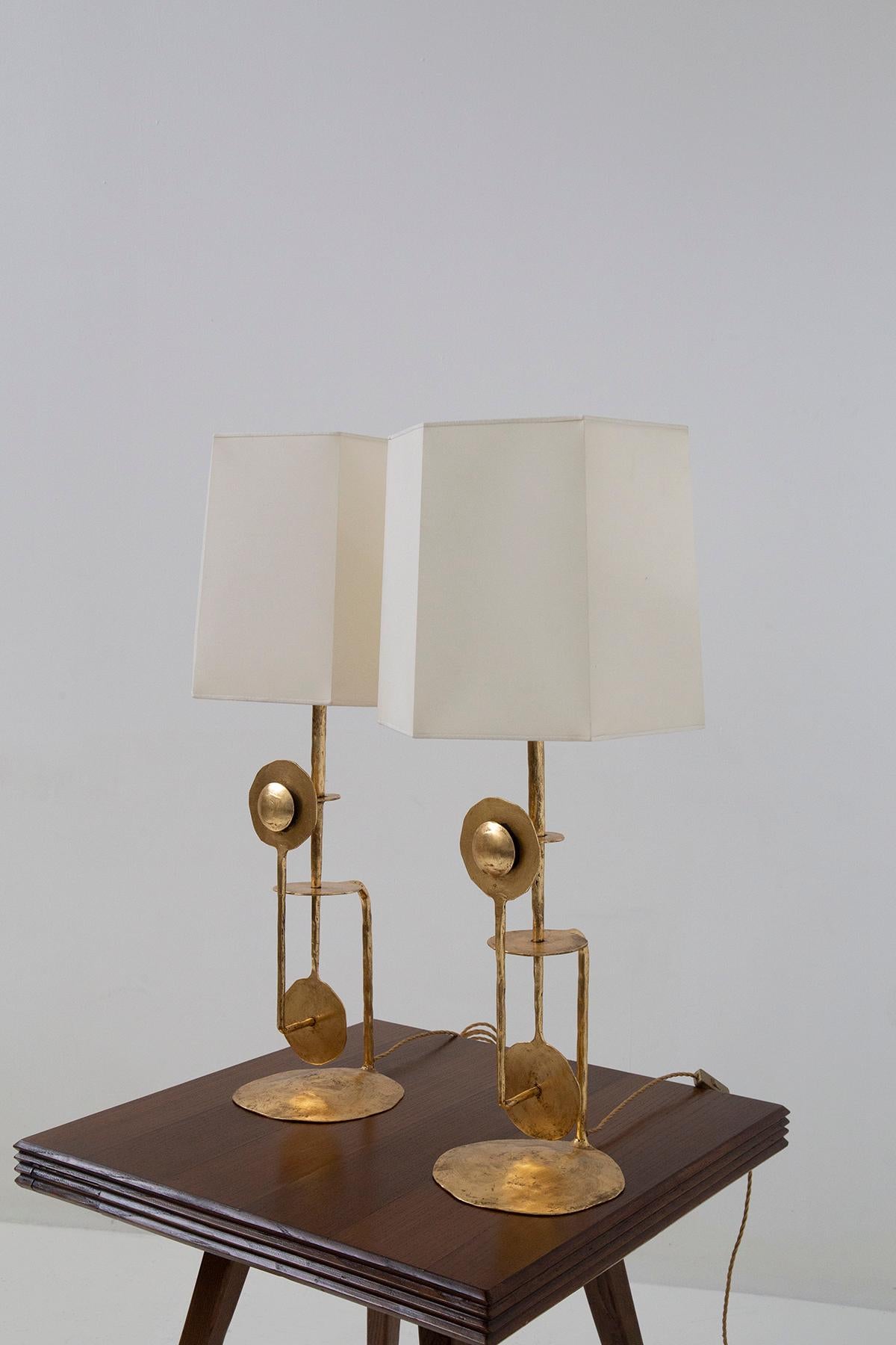Allow me to introduce you to an exquisite pair of Italian brutalist table lamps from the 1980s. Crafted with intricate detail in gleaming golden metal, these lamps are a stunning testament to Italian craftsmanship, an embodiment of artistry.

The