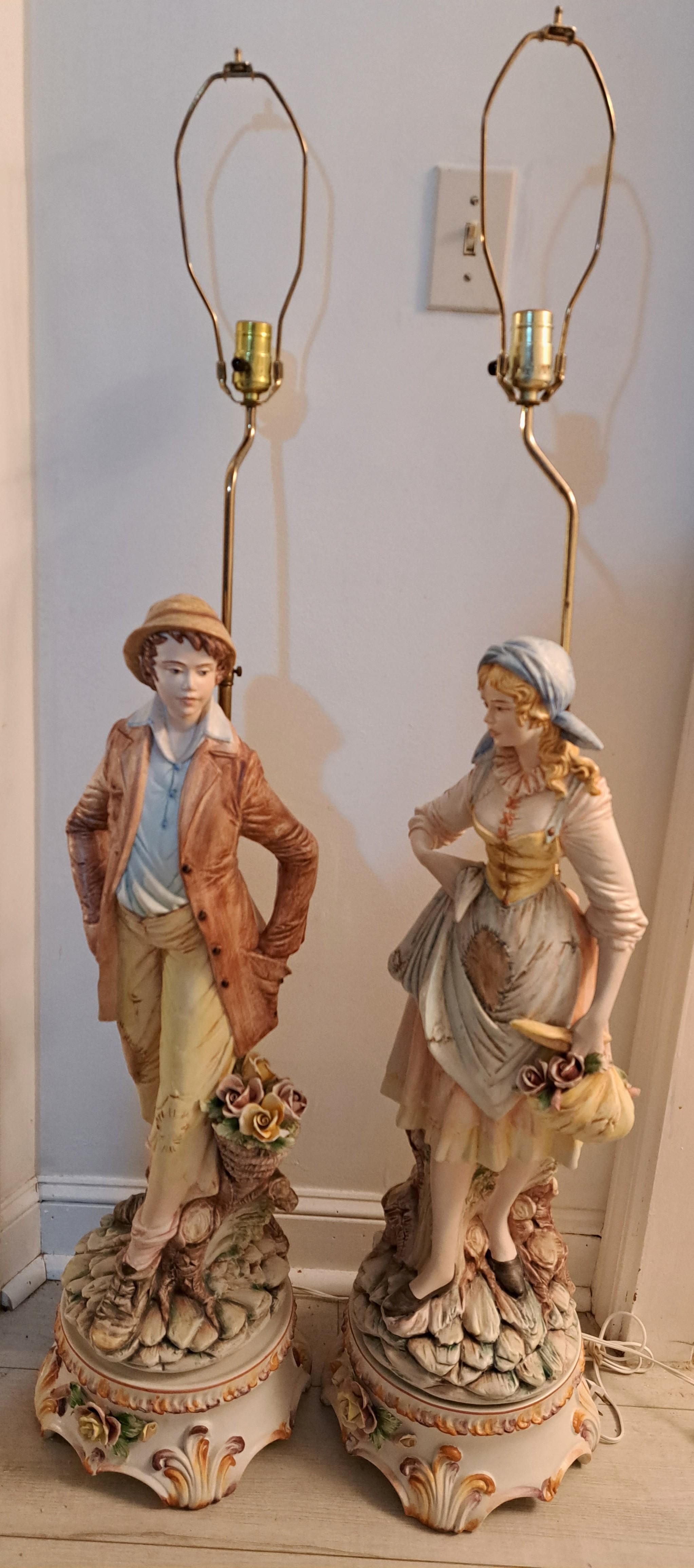 Ein Paar fein gearbeitete figurale Capodimonte-Porzellanlampen. Männliche und weibliche Figuren von Mädchen und Jungen aus dem ländlichen Raum. Gefertigt in Italien. Besteht aus einem figuralen Porzellansockel und einer hohen Messinghalterung mit