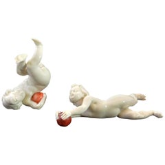 Pair of Italian Capodimonte Putti with Orbs
