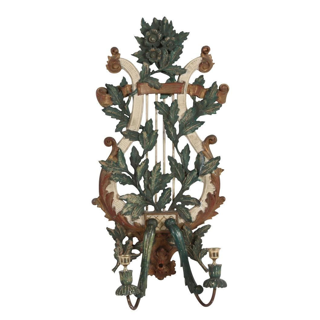 Une paire d'appliques à bougies en bois sculpté italien avec des détails peints en doré, vert et crème sur le dos en forme de lyre et de branche.