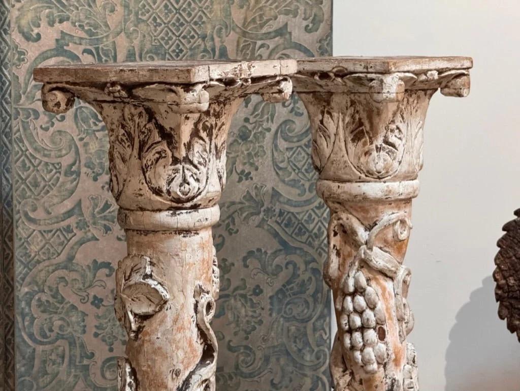Paire de colonnes baroques italiennes en creme peinte, 18e-19e s., les colonnes trois-quarts rondes sont ornées de chapiteaux ioniques et d'étendards enveloppés de raisins et de vignes peints, sur des bases carrées sculptées.

